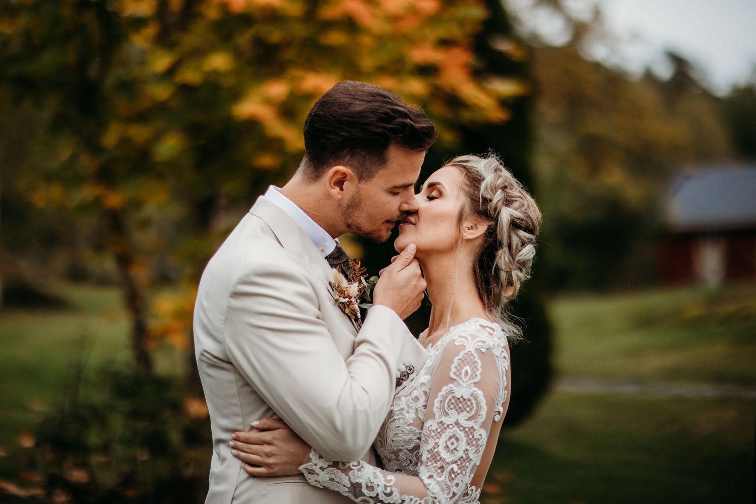 Intimate autumn wedding portraits captured against fall foliage backdrop.