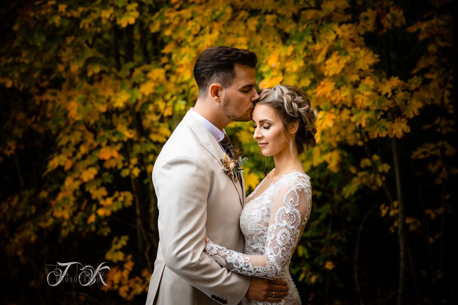 Romantic autumn wedding portraits with golden foliage in background.