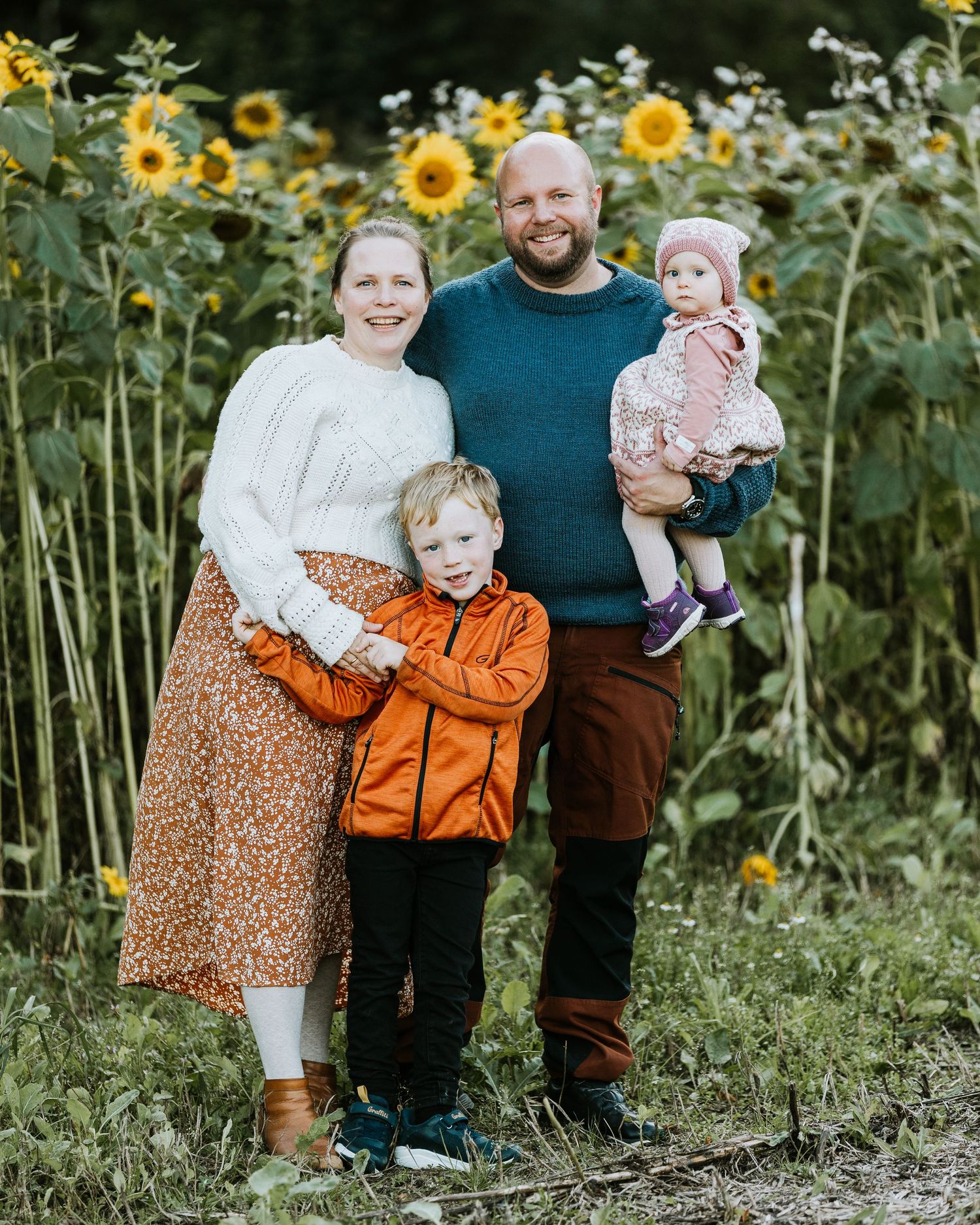 Family photo shoot in a vibrant sunflower field during summer.