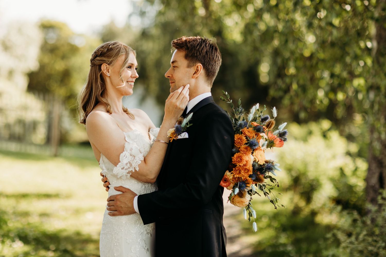 Sunlit outdoor wedding portraits captured in a natural garden setting.