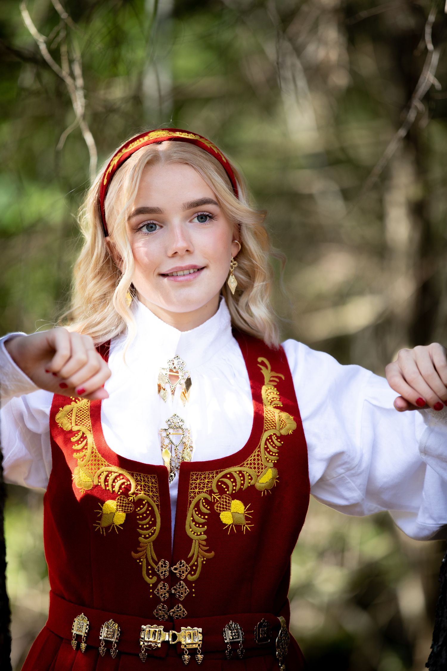 Red and gold embroidered Norwegian bunad vest with traditional decorative elements.