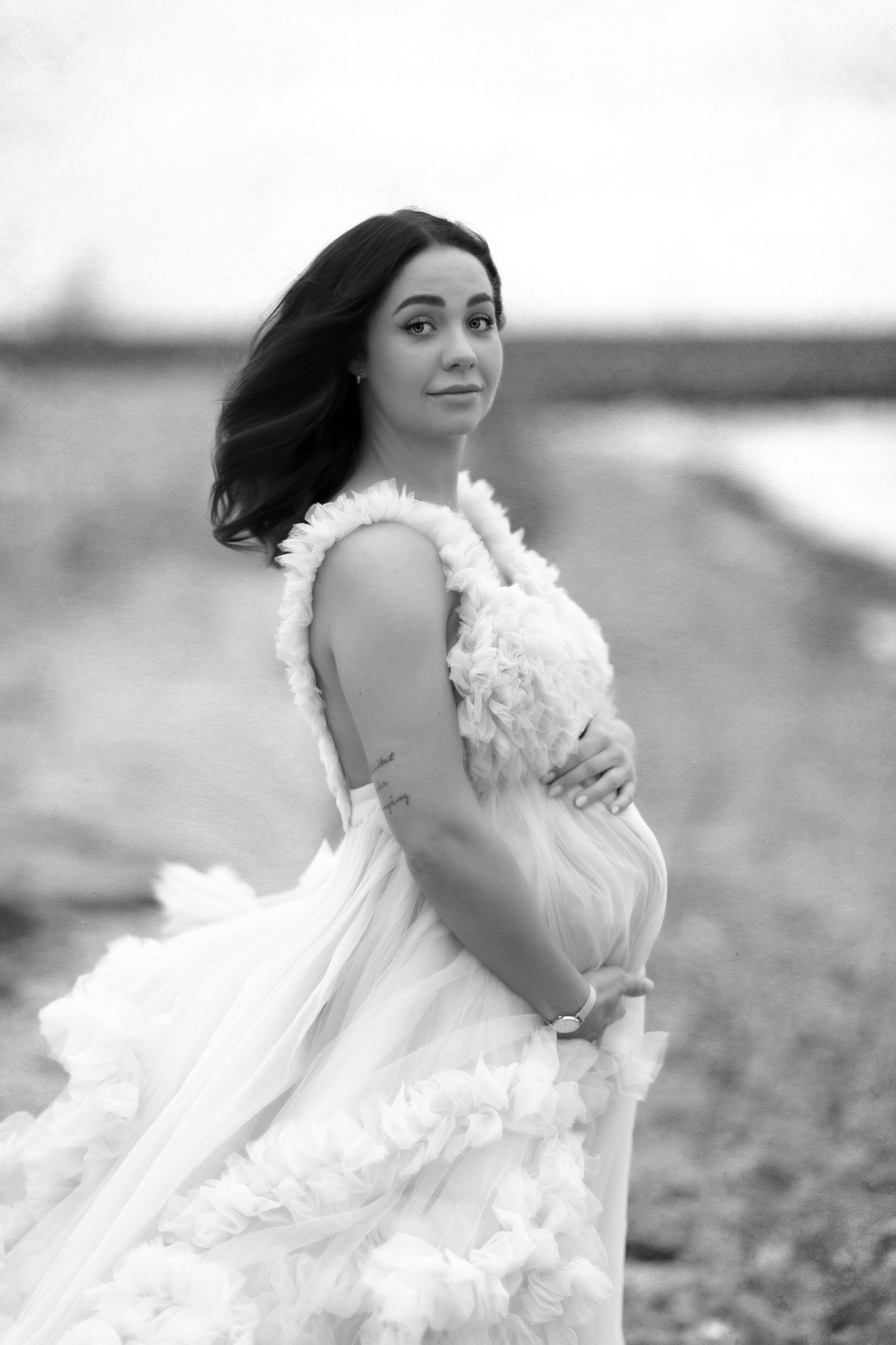 Artistic black and white maternity photos with flowing white dress in motion.