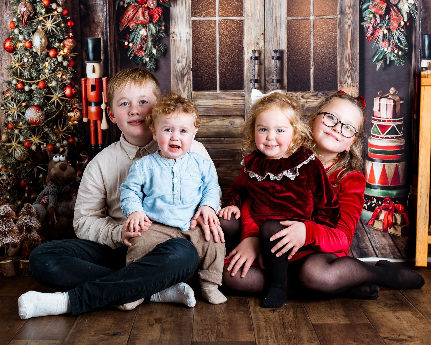 Candid family moments captured against rustic Christmas backdrop with festive decorations.