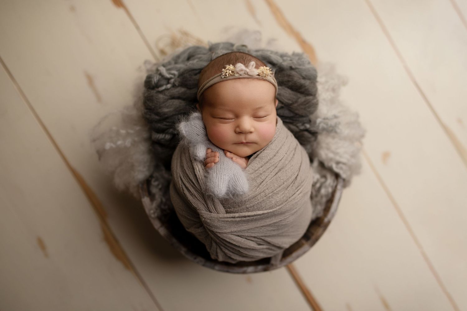 Nyfødtfotograf Moss – Sovende baby i grå svøp på lyst tregulv, Tara Kristine Photography