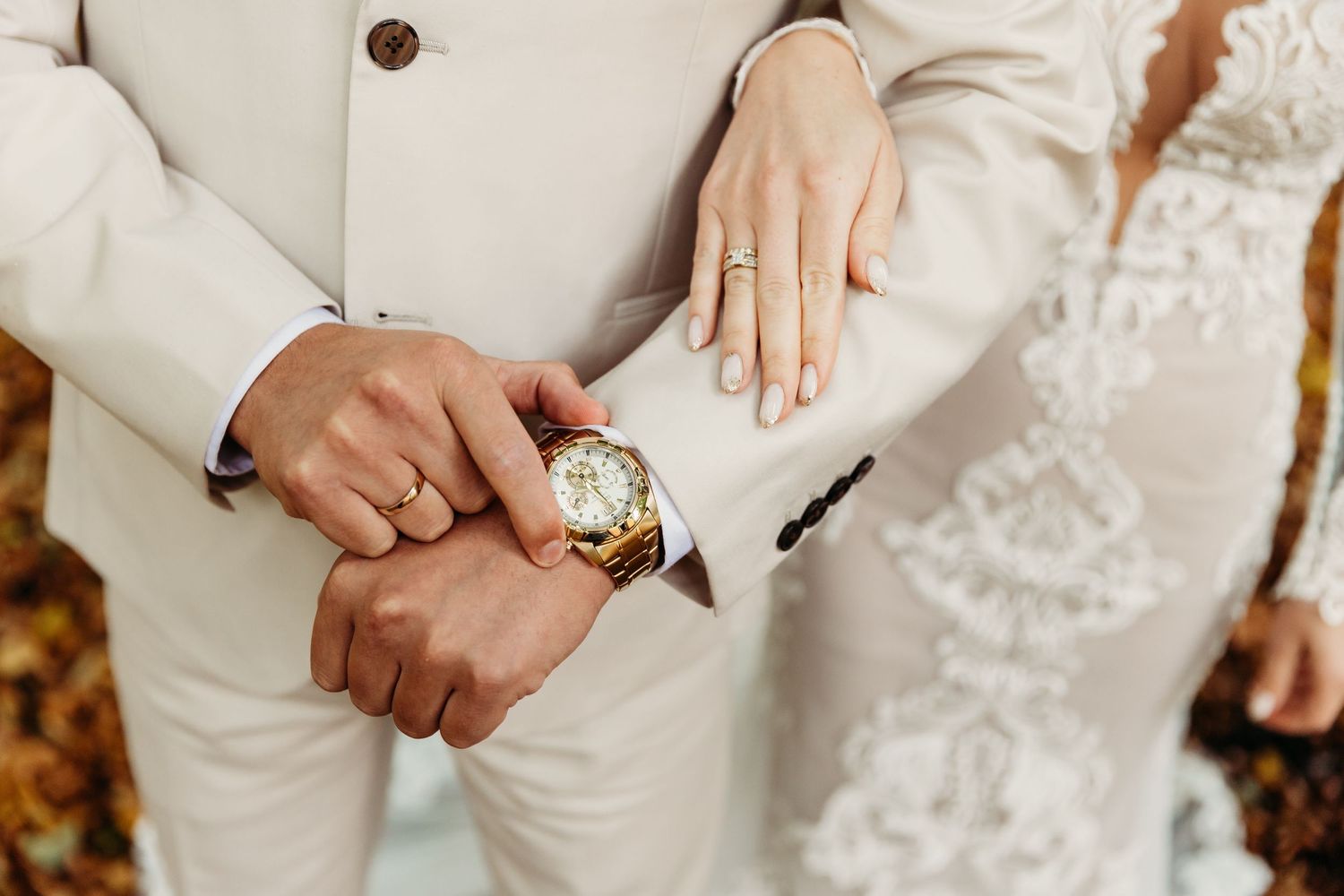 Close-up details of wedding attire showing lace dress and white suit details.