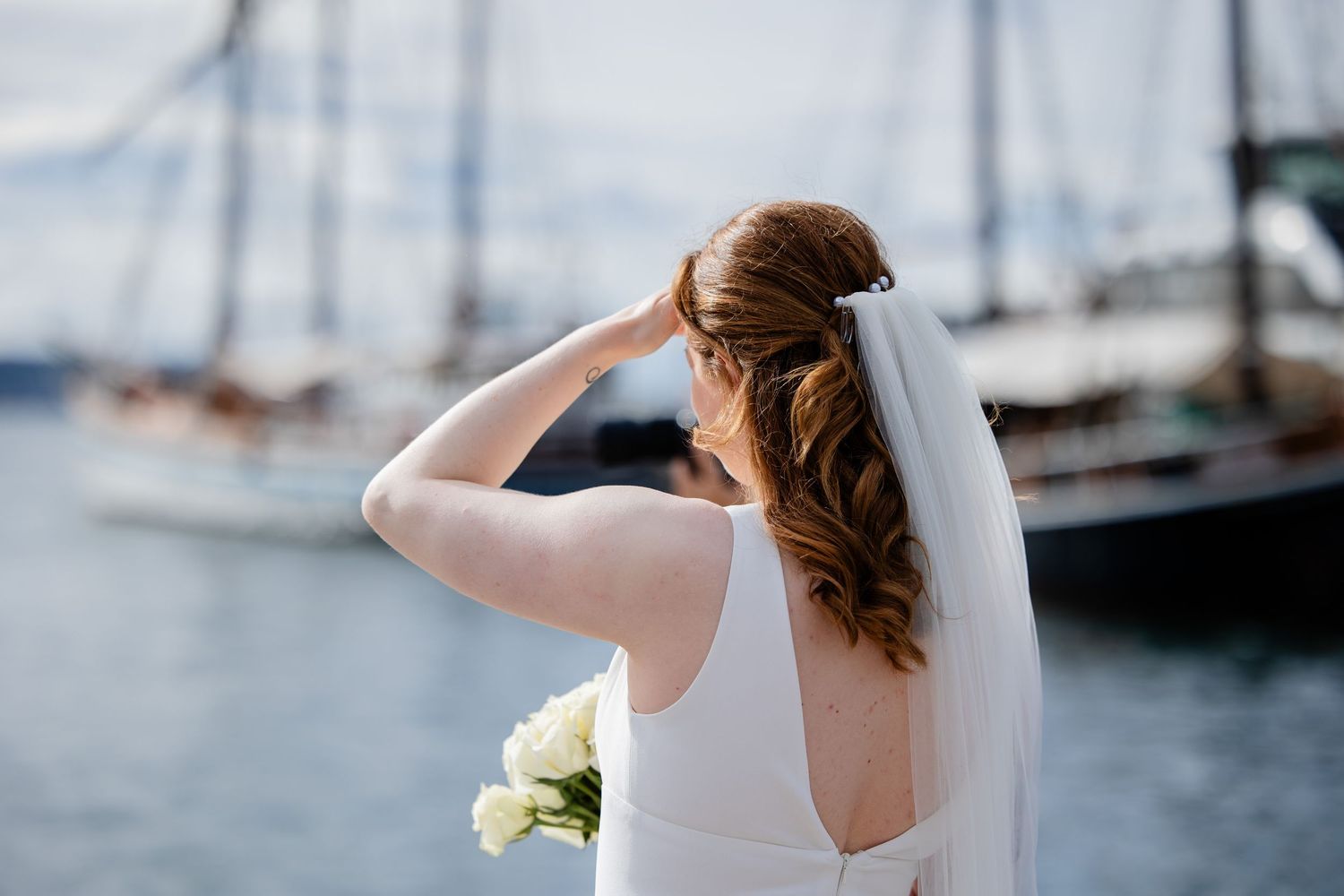 Stemningsfullt detaljbilde av bruden ved sjøen i Oslo sentrum med maritime omgivelser i bakgrunnen.