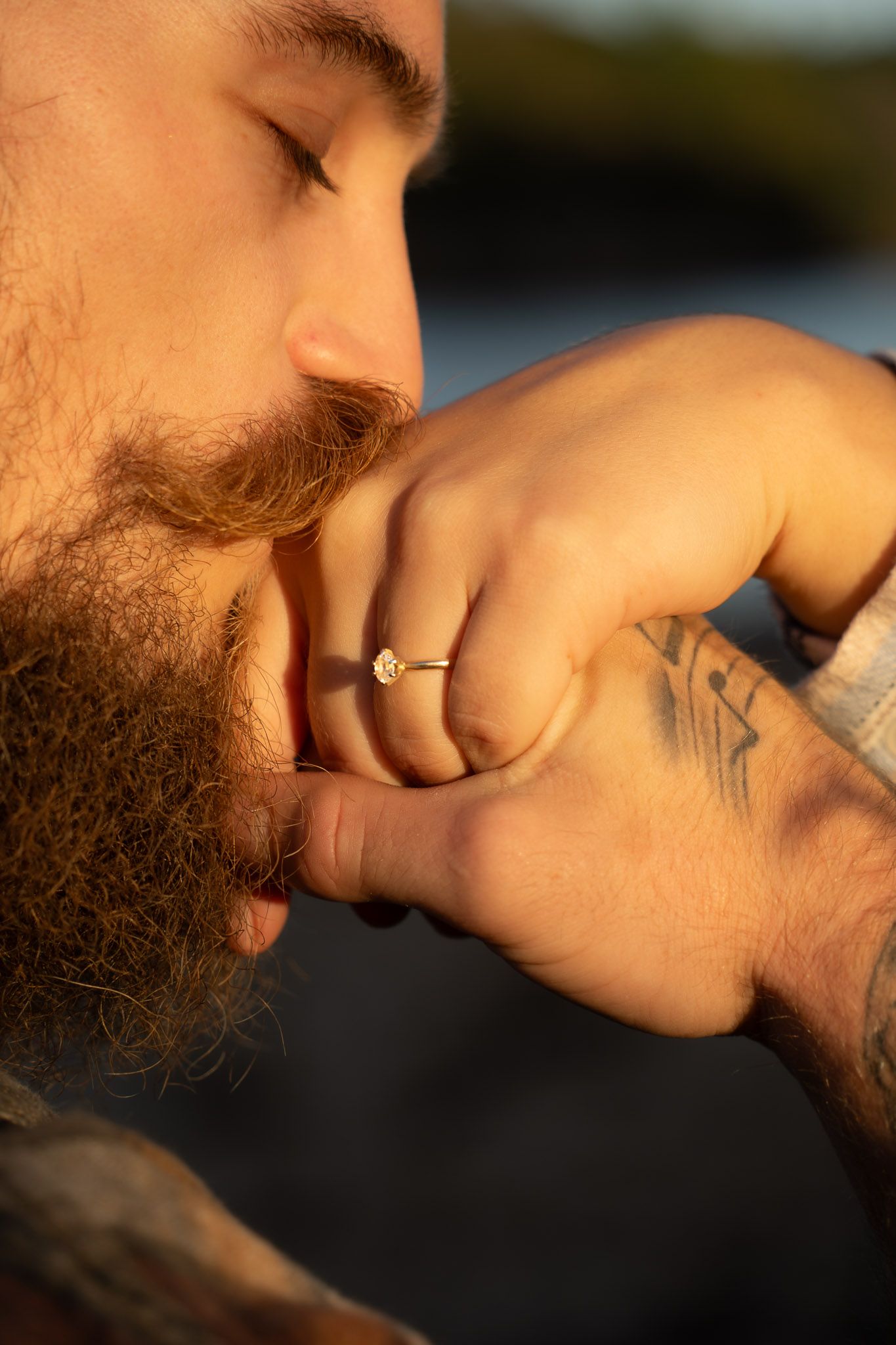 Wisconsin Couple and Engagement Photographer - Hand with engagement ring during sunset with tattoo kissed by a man with beard and mustache.