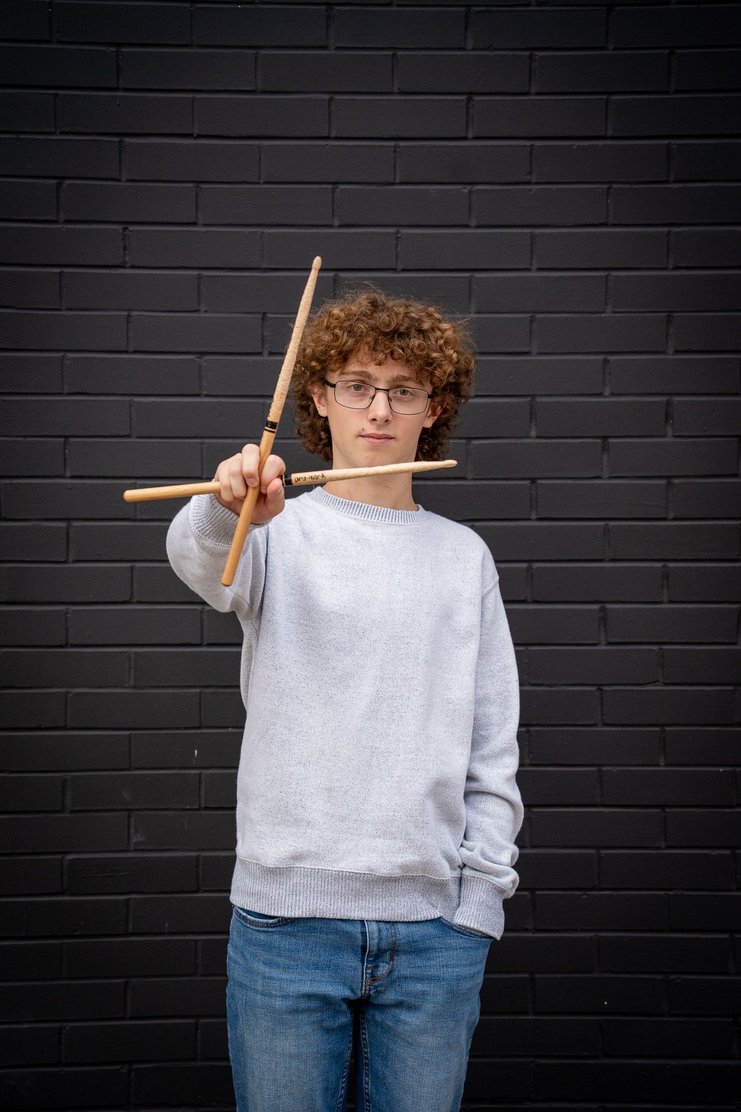 Wisconsin Senior and Portrait Photographer - Drummer senior boy smiling holding drumsticks in Wisconsin during a summer senior portrait.