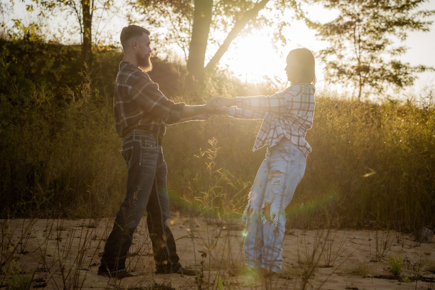 Wisconsin Couple and Engagement Photographer - Couple dancing on a beach in fall during an engagement session in Wisconsin during sunset.