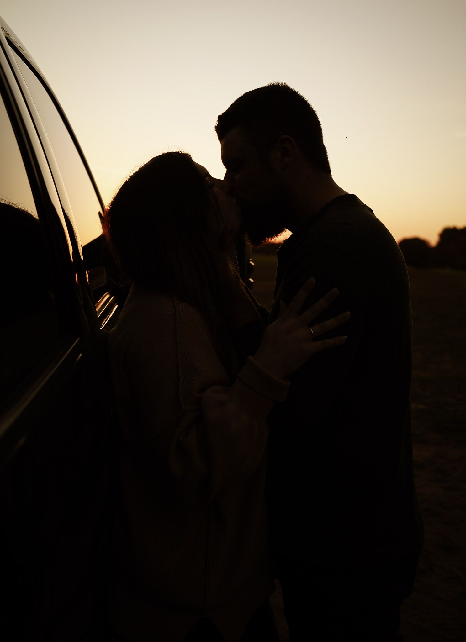 Wisconsin Couple and Engagement Photographer - Sunset photo of couple silhouette during engagement session with a trucks in a field.