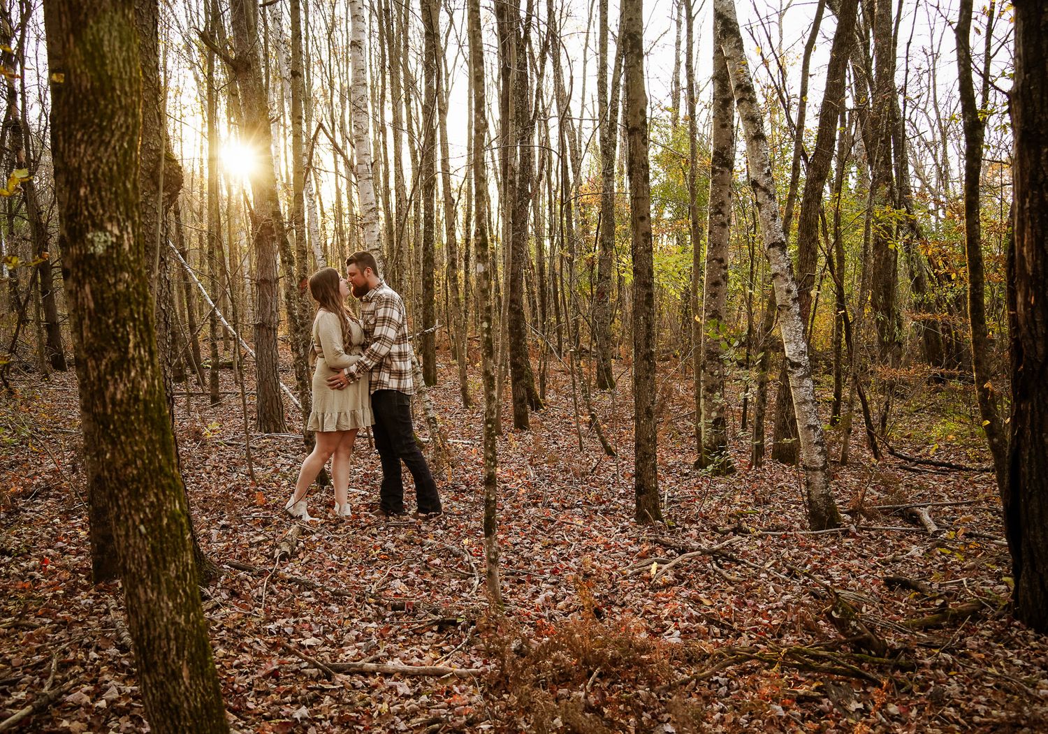 Wisconsin Couple and Engagement Photographer - Couple kissing in woods in fall during an engagement session during sunset in Wisconsin.