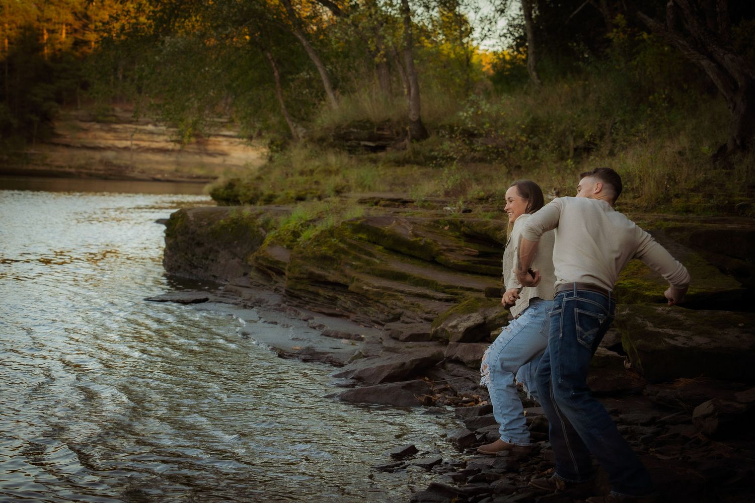 Wisconsin Couple and Engagement Photographer - Couple skipping rocks in fall during an engagement session in Wisconsin during sunset.