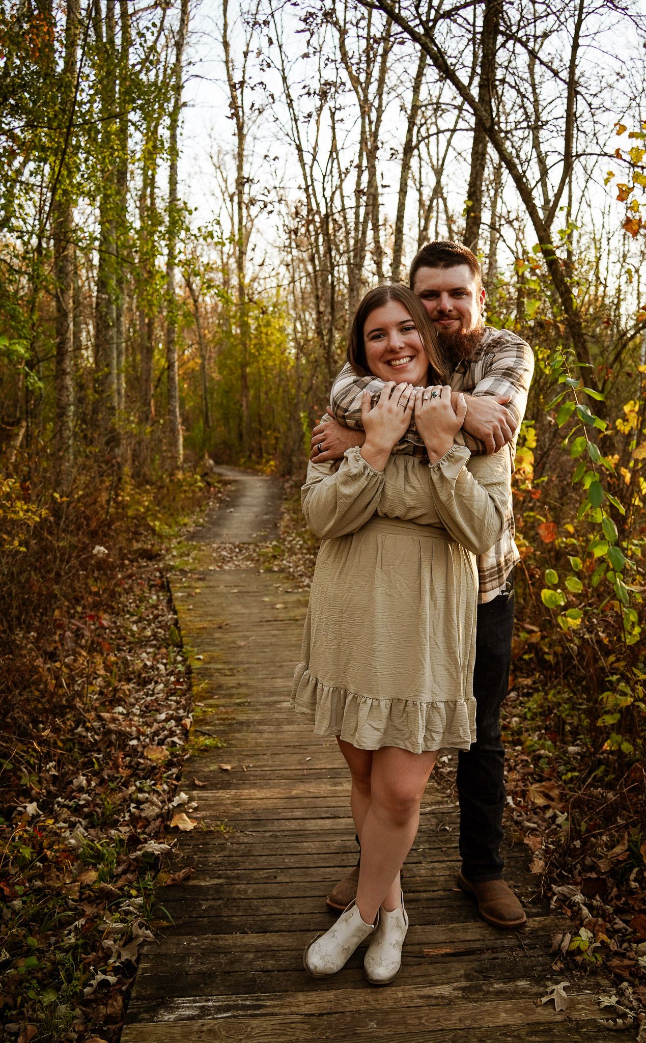 Wisconsin Couple and Engagement Photographer - Couple hugging in woods in fall during an engagement session during sunset in Wisconsin.