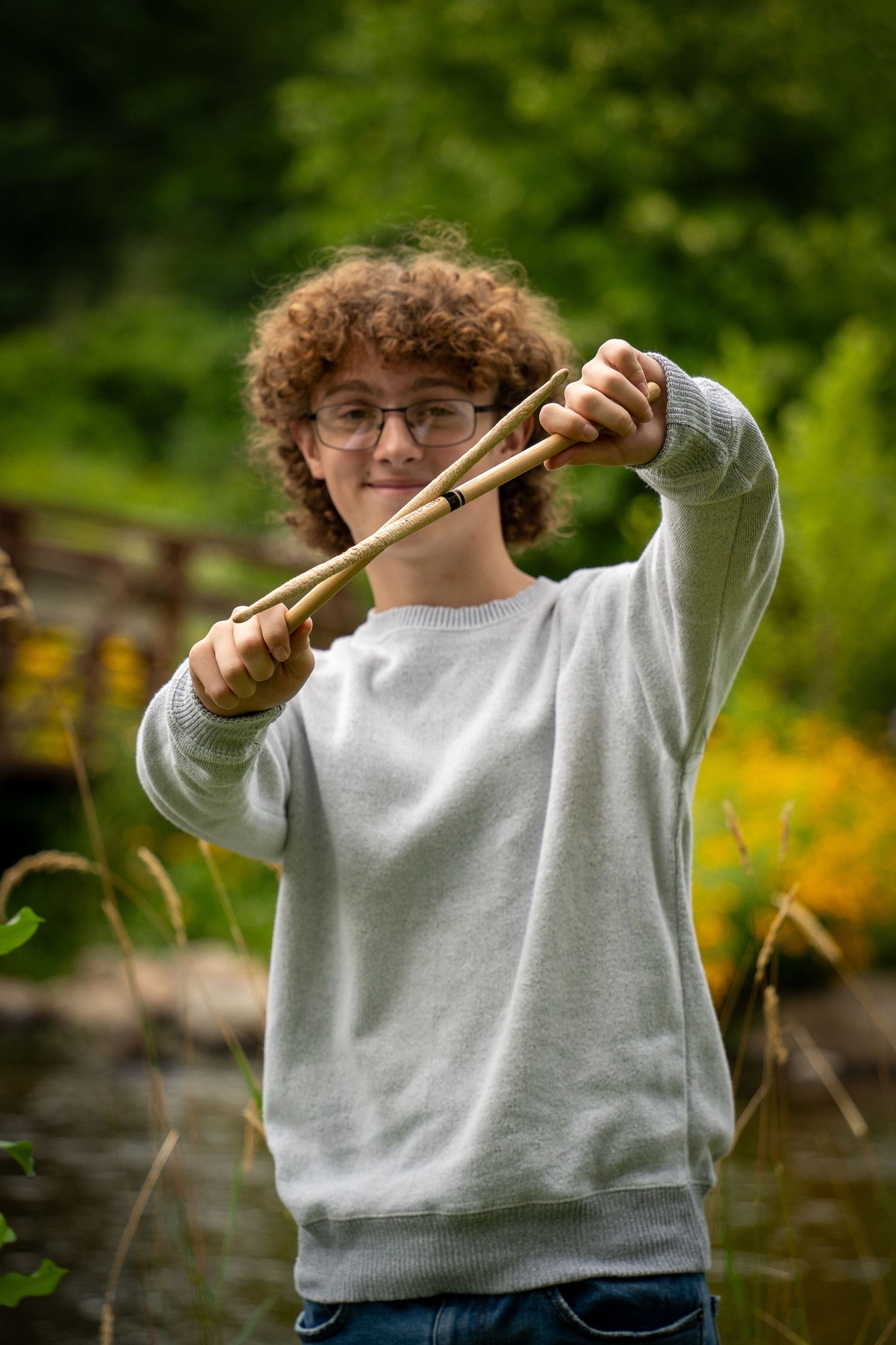 Wisconsin Senior and Portrait Photographer - Drummer senior boy smiling holding drumsticks in Wisconsin during a summer senior portrait.