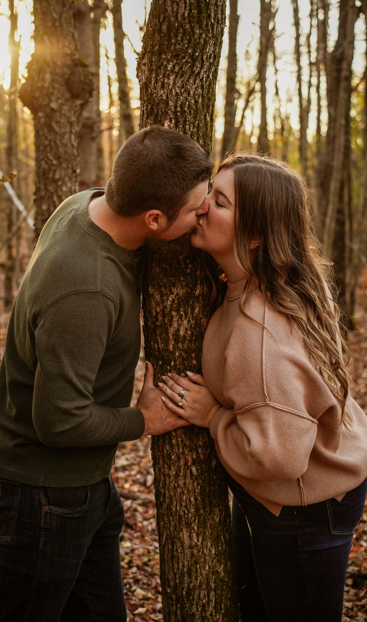 Wisconsin Couple and Engagement Photographer - Couple kissing in woods in fall during an engagement session during sunset in Wisconsin.