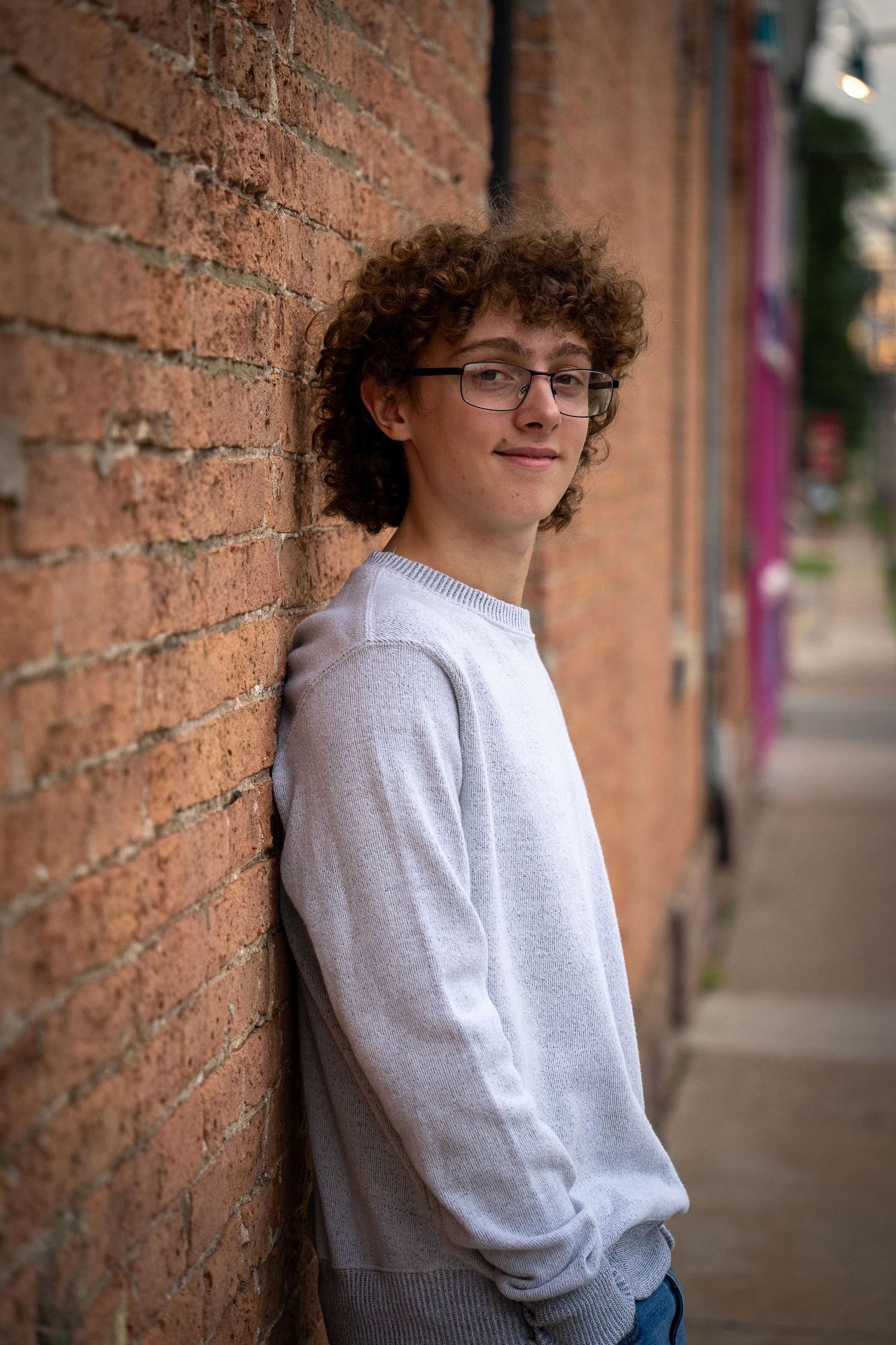 Wisconsin Senior and Portrait Photographer - Boy leaning on brick wall in the city in Wisconsin during a summer senior portrait session.
