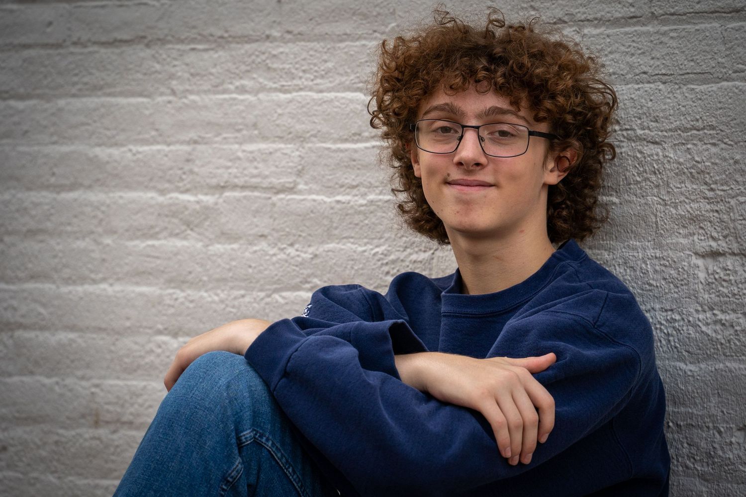 Wisconsin Senior and Portrait Photographer - Boy leaning on brick wall in the city in Wisconsin during a summer senior portrait session.