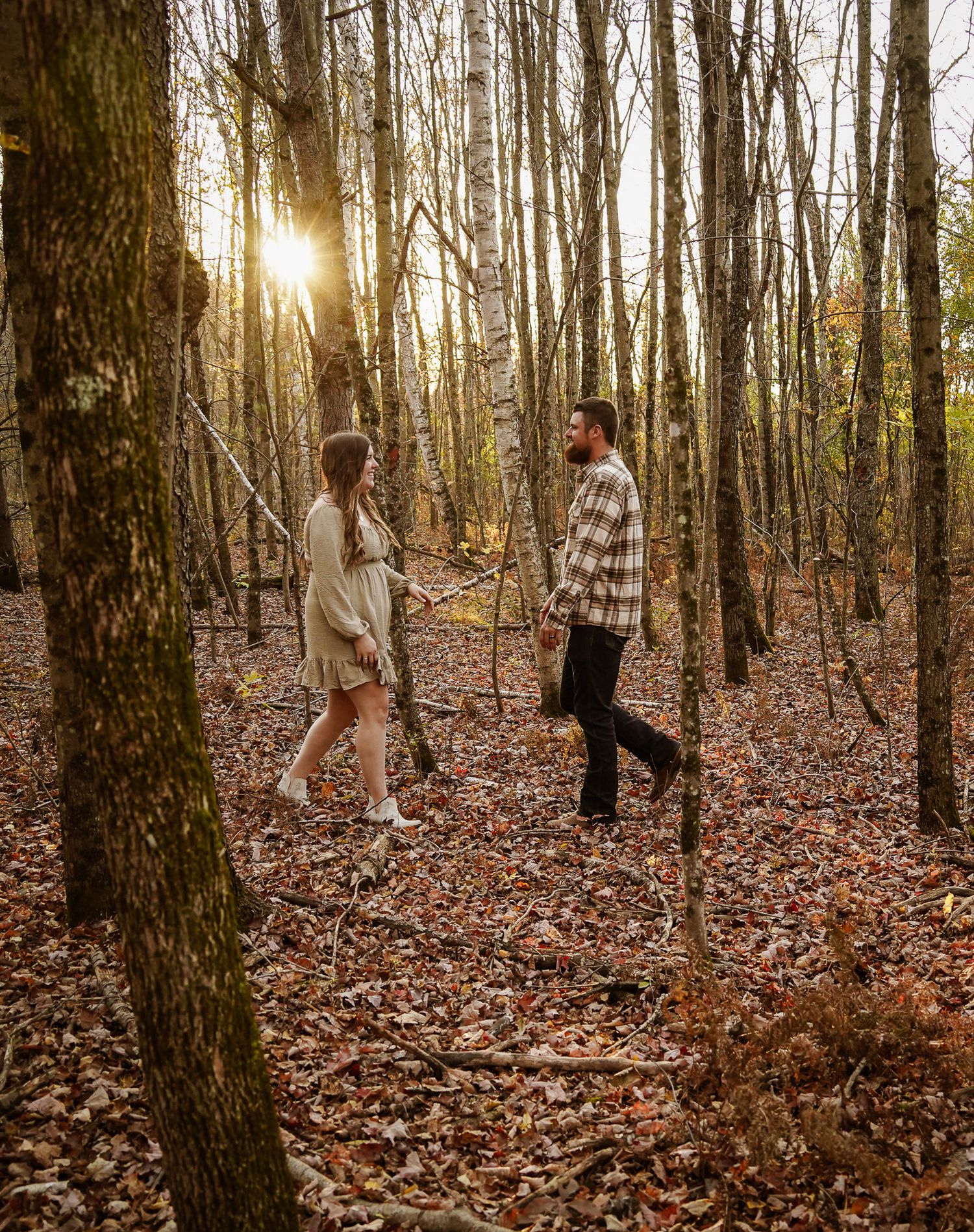 Wisconsin Couple and Engagement Photographer - Couple walking in woods in fall during an engagement session during sunset in Wisconsin.