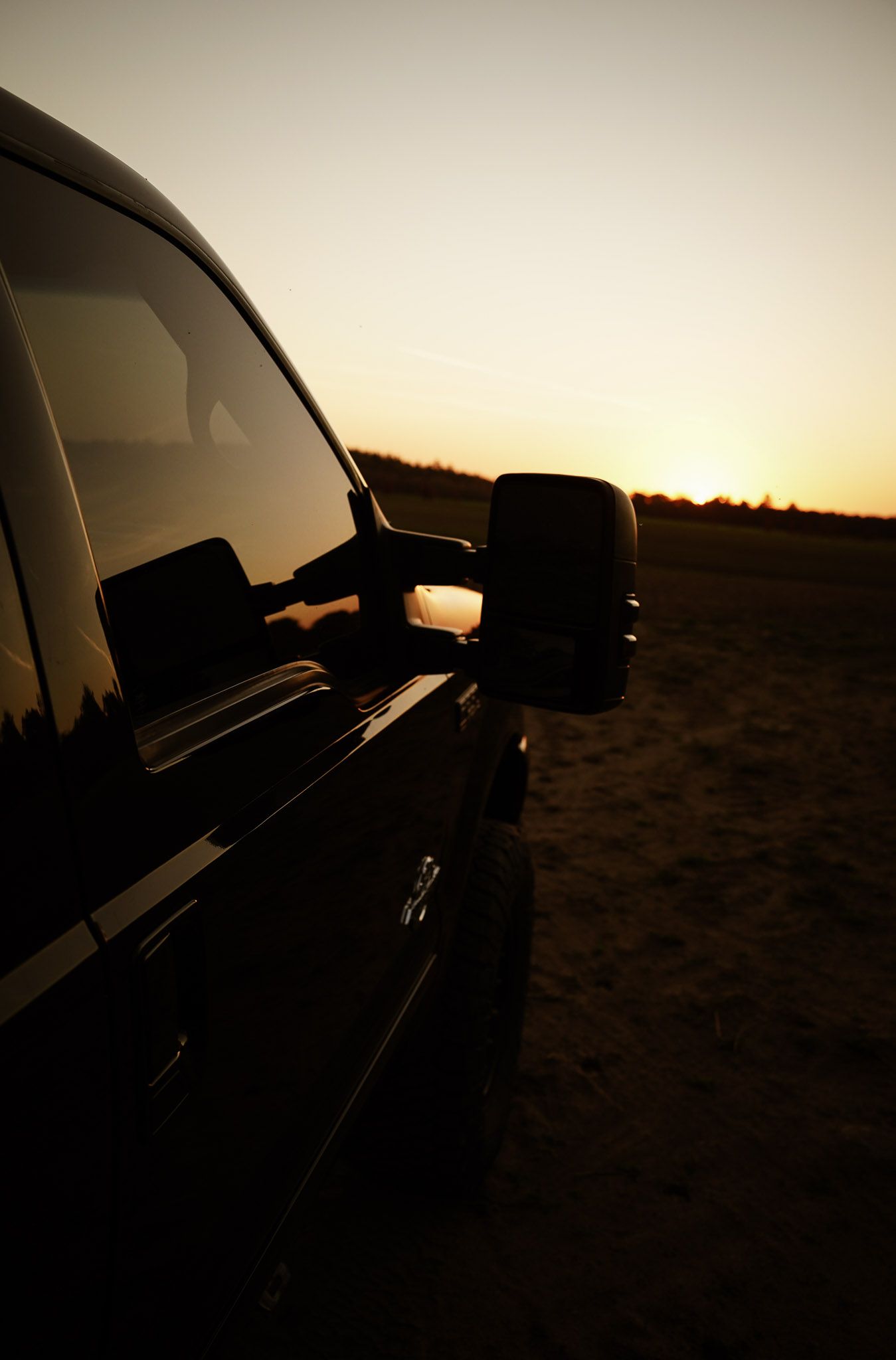 Wisconsin Couple and Engagement Photographer - Sunset photo of couple silhouette during engagement session with a trucks in a field.