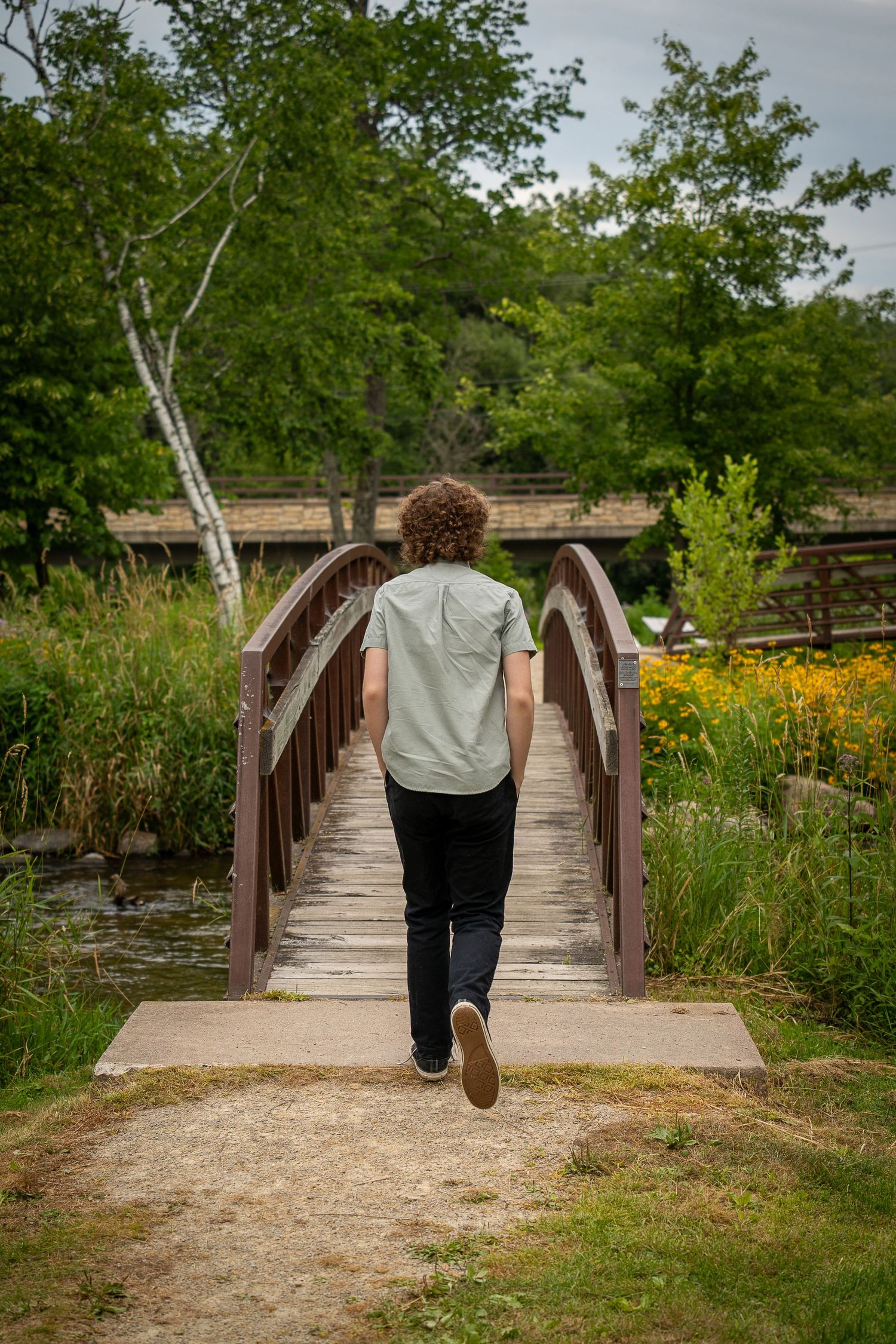 Wisconsin Senior and Portrait Photographer - Boy walking on a bridge in Wisconsin during a summer senior portrait session.