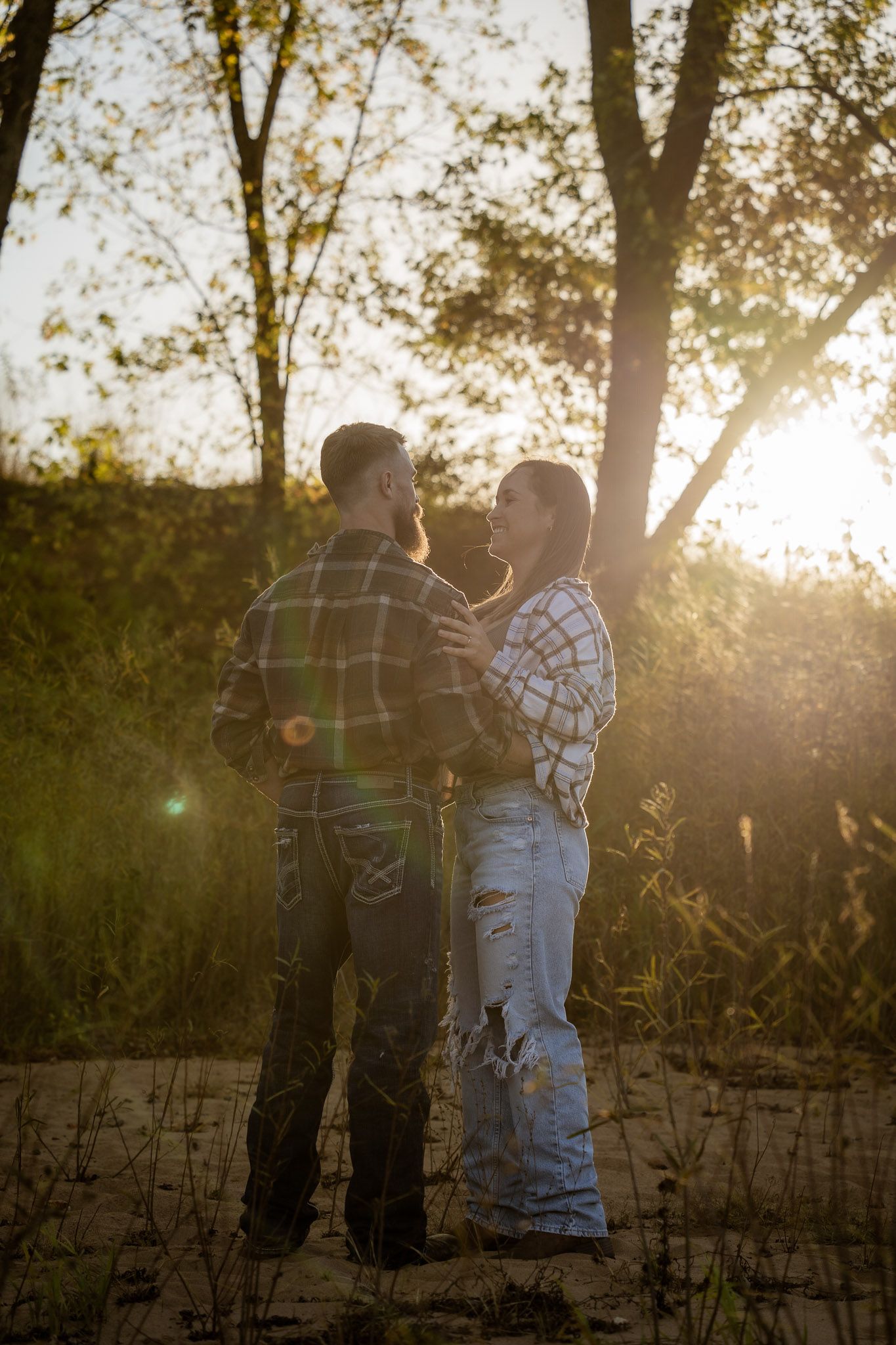 Wisconsin Couple and Engagement Photographer - Couple dancing on a beach in fall during an engagement session in Wisconsin during sunset.