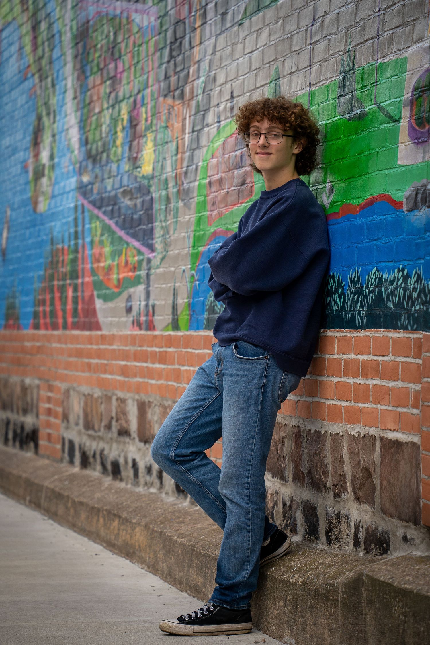 Wisconsin Senior and Portrait Photographer - Boy leaning on wall with city street art in Wisconsin during a summer senior portrait session.