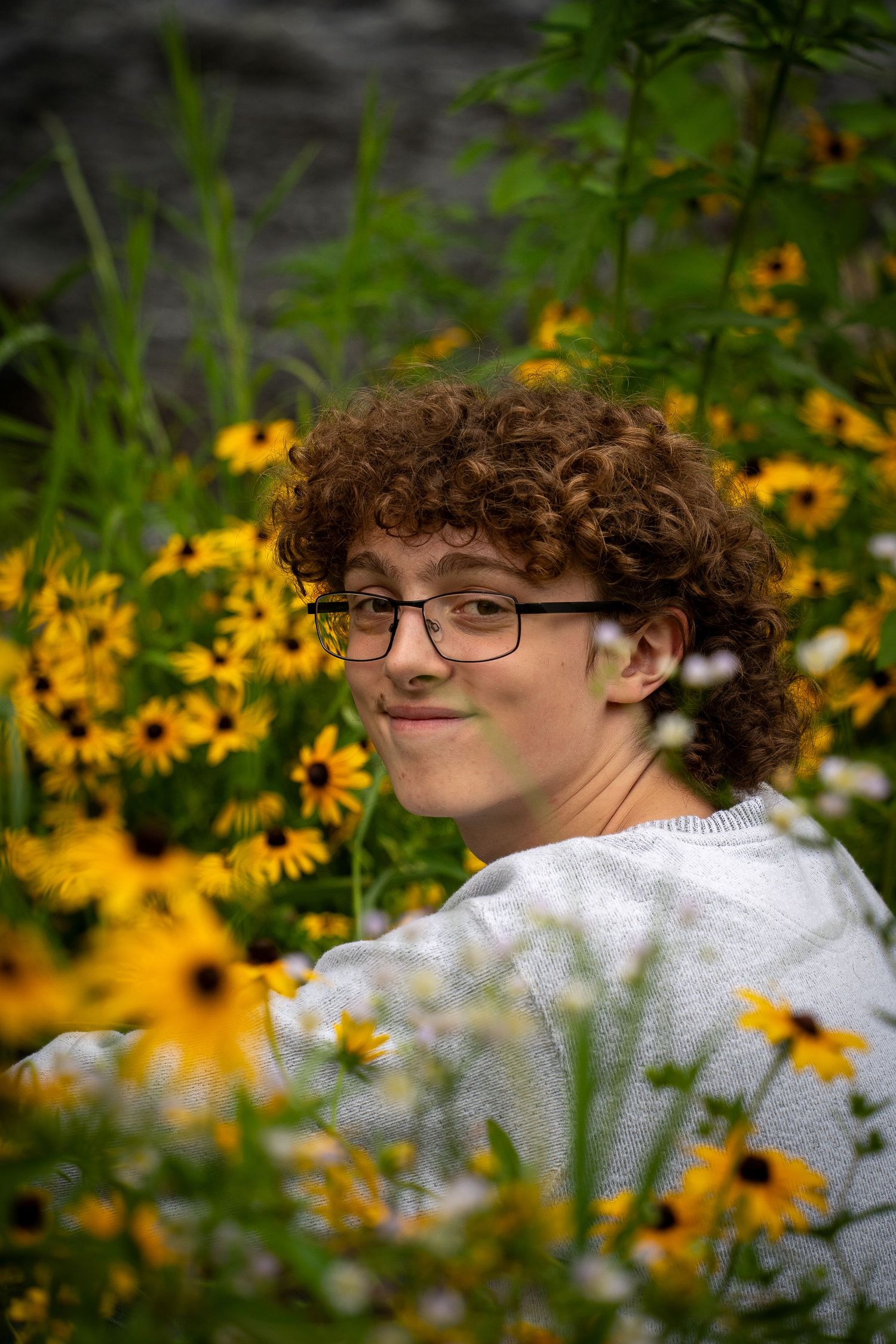 Wisconsin Senior and Portrait Photographer - Boy smiling with yellow flowers in Wisconsin during a summer senior portrait session.