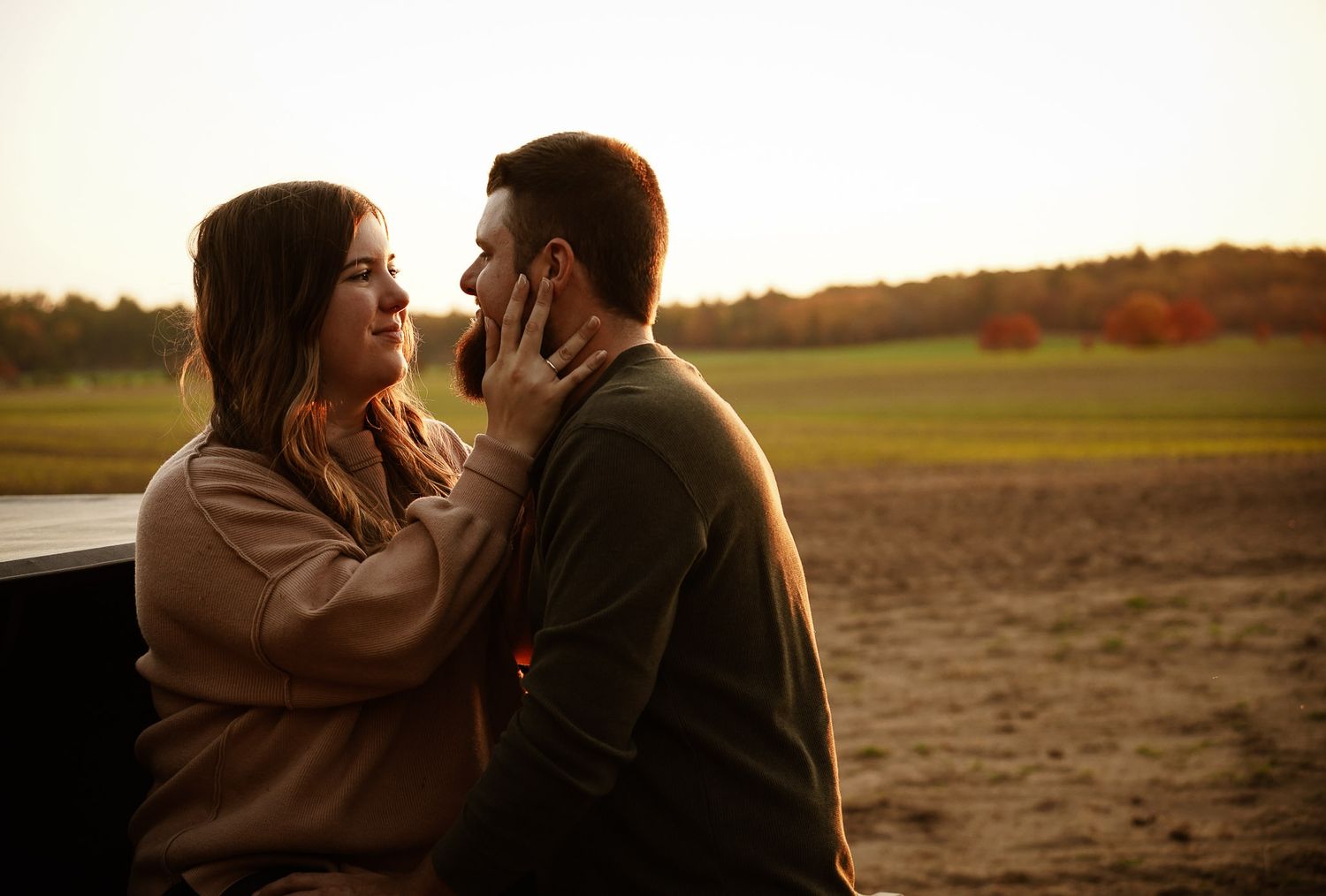 Wisconsin Couple and Engagement Photographer - Sunset photo of couple silhouette during engagement session with a trucks in a field.