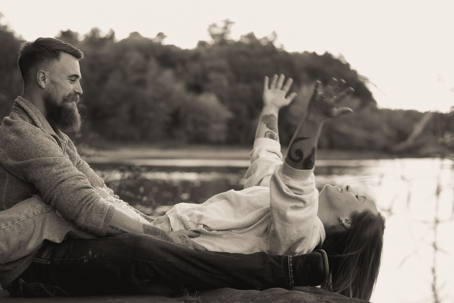 Wisconsin Couple and Engagement Photographer - Couple happy on riverbank in fall during an engagement session in Wisconsin during sunset.
