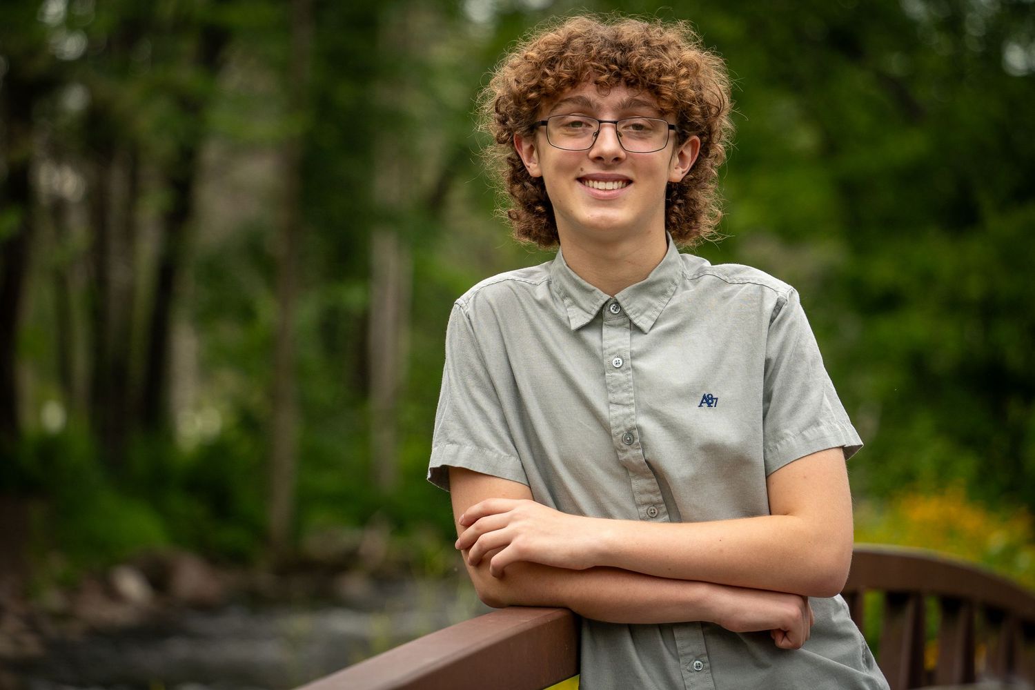 Wisconsin Senior and Portrait Photographer - Boy smiling on a bridge in Wisconsin during a summer senior portrait session.