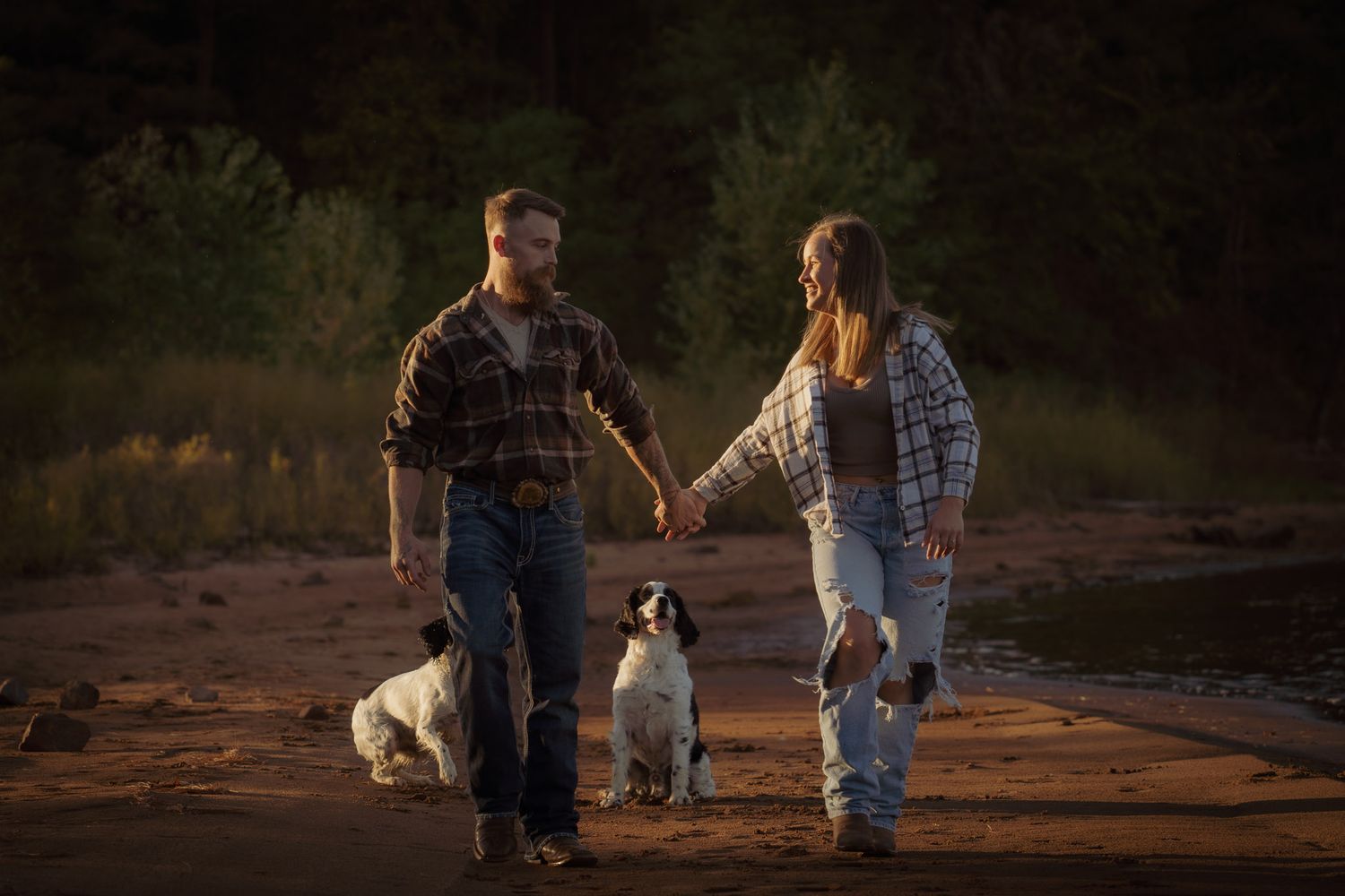 Wisconsin Couple and Engagement Photographer - Couple with dog walking on a beach in fall during an engagement session in WI during sunset.