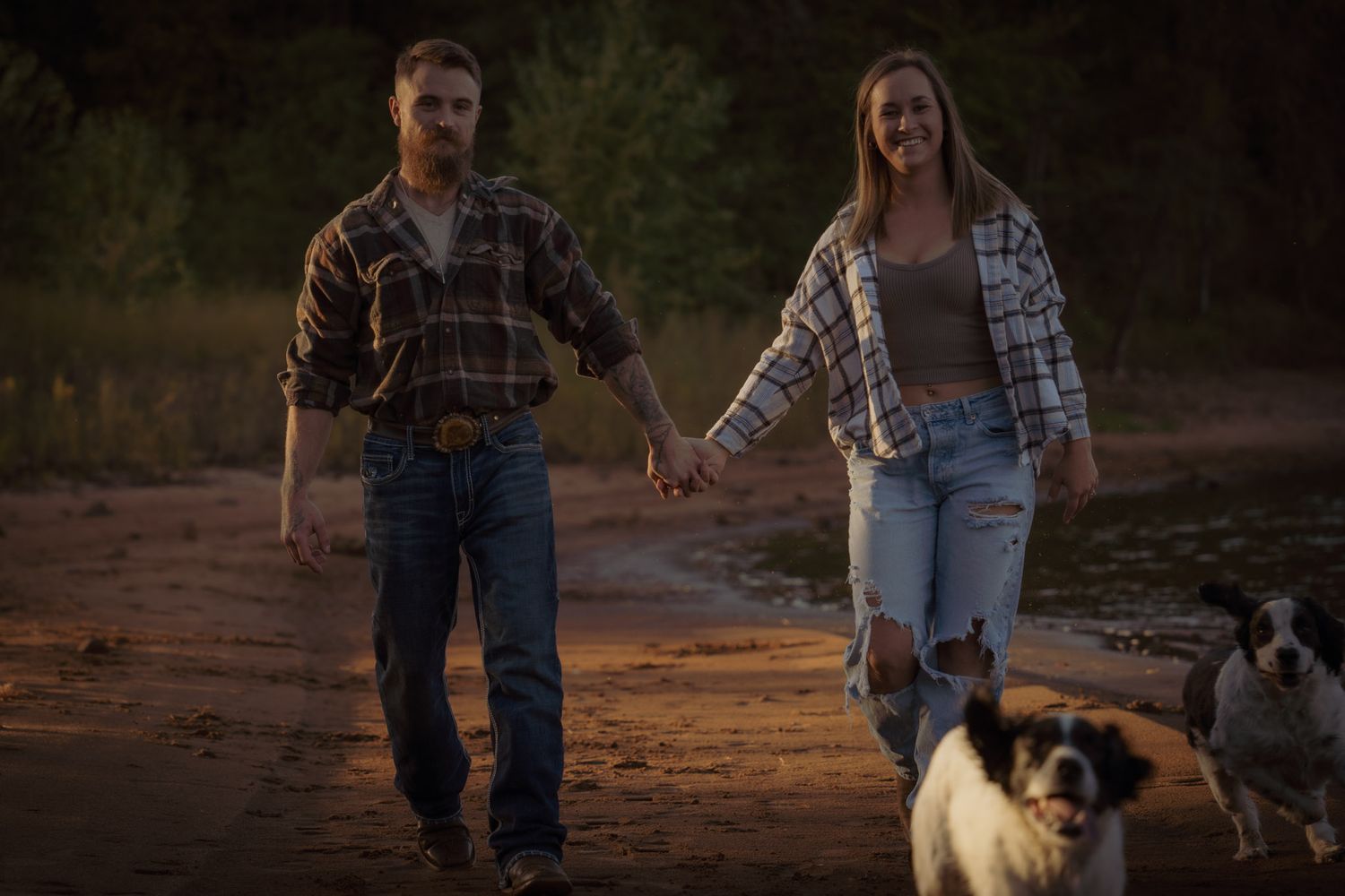 Wisconsin Couple and Engagement Photographer - Couple with dog walking on a beach in fall during an engagement session in WI during sunset.