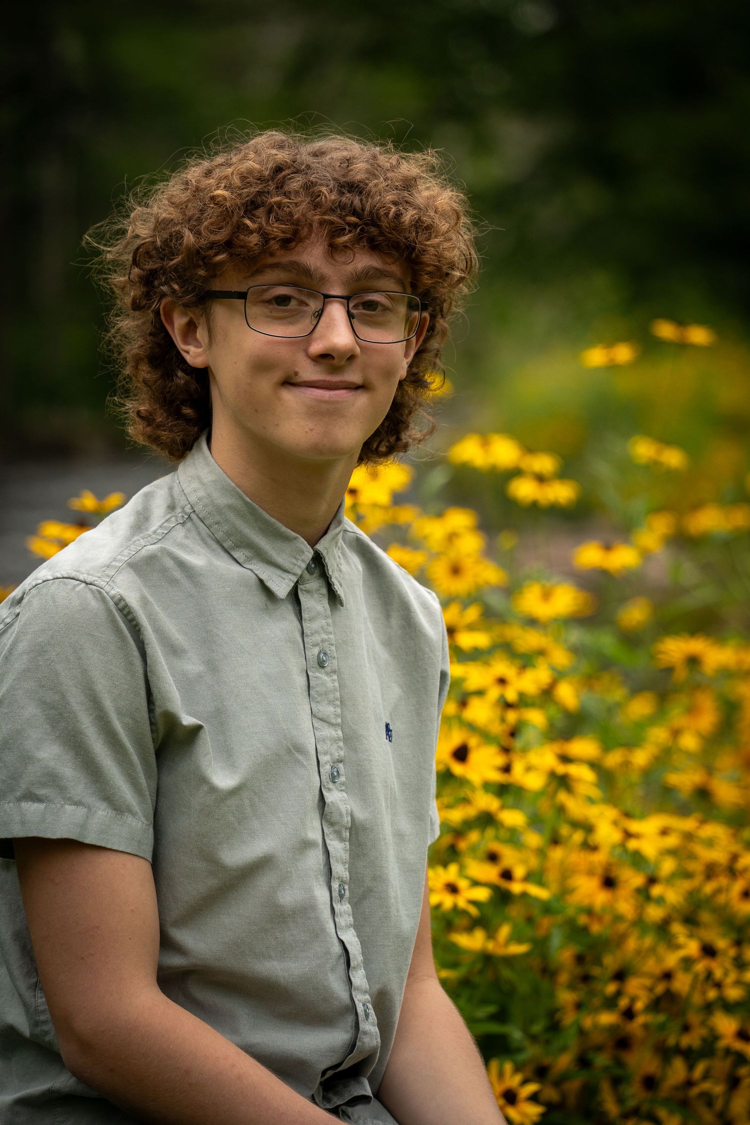 Wisconsin Senior and Portrait Photographer - Boy smiling with yellow flowers in Wisconsin during a summer senior portrait session.