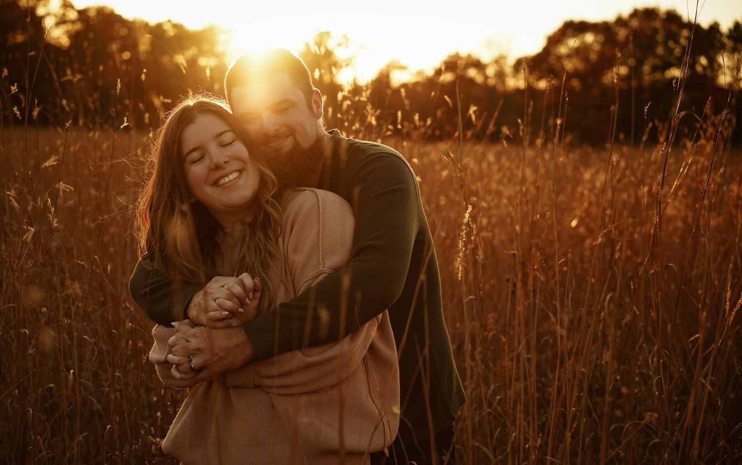 Wisconsin Couple and Engagement Photographer - Couple hugging in a field in fall during an engagement session during sunset.