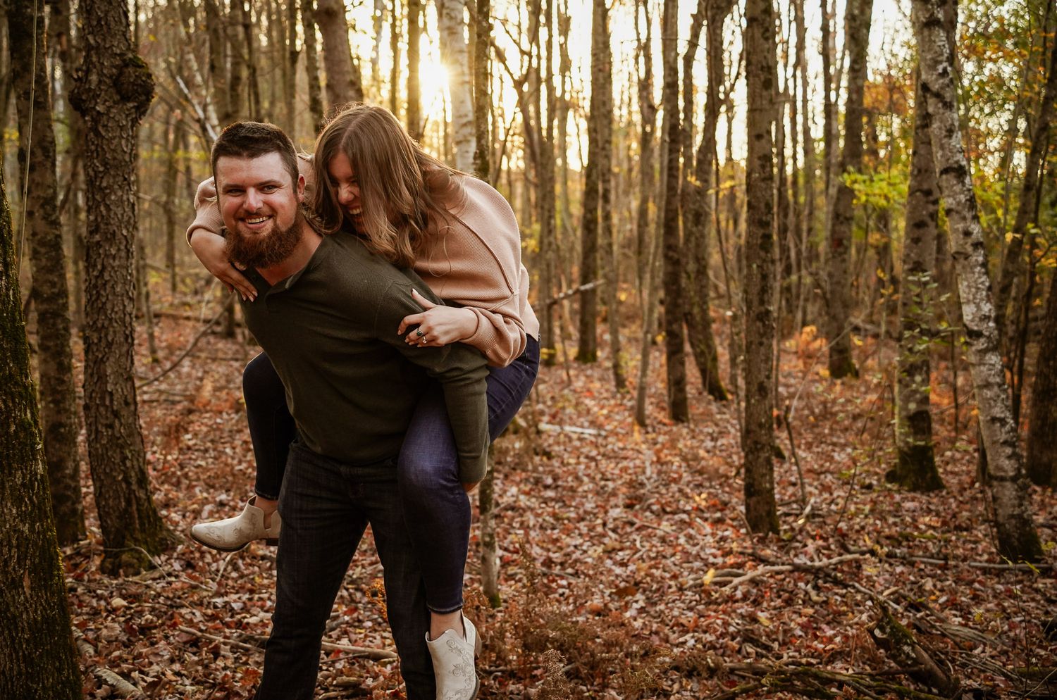 Wisconsin Couple and Engagement Photographer - Couple laughing in woods in fall during an engagement session during sunset in Wisconsin.