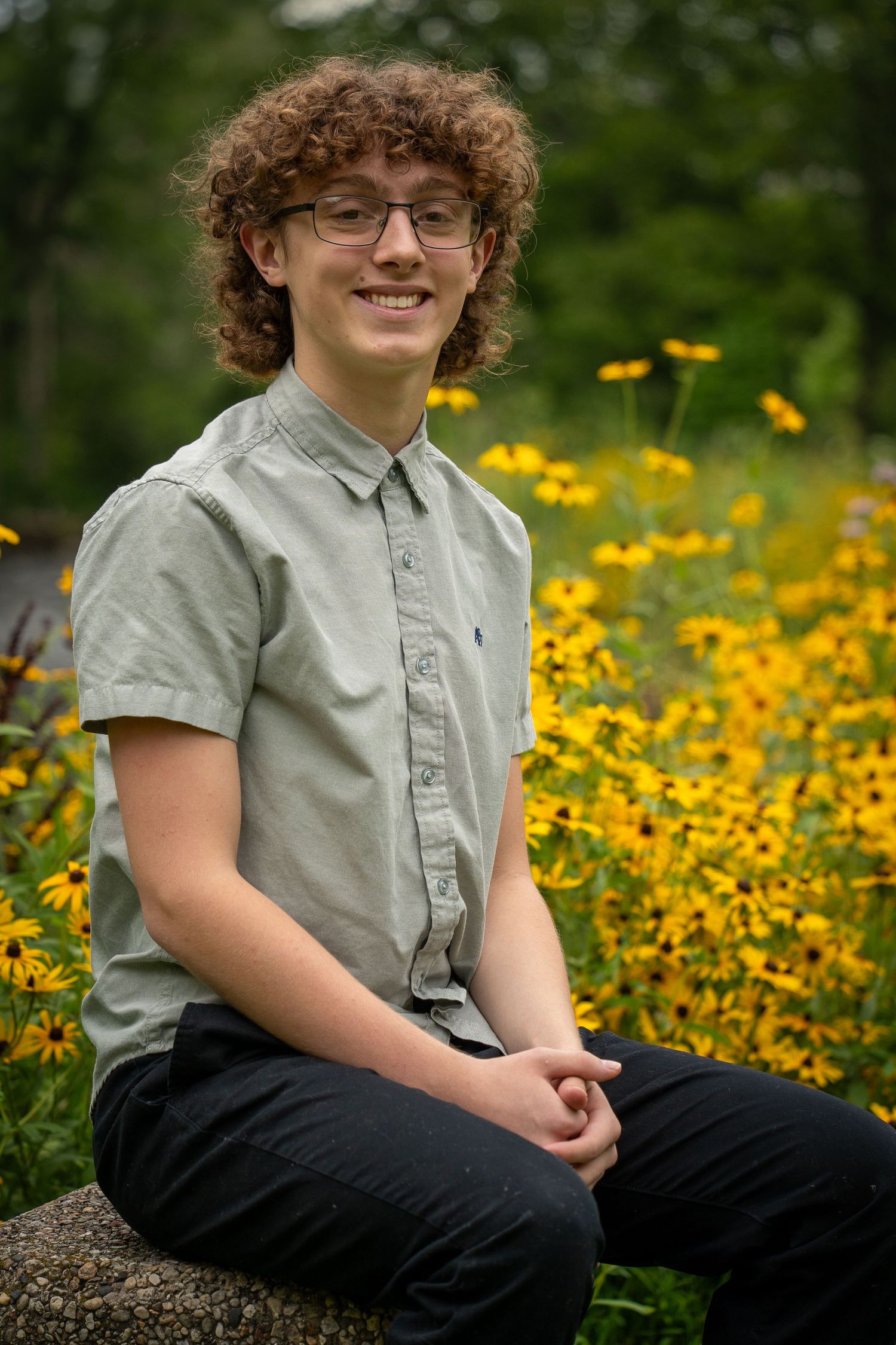 Wisconsin Senior and Portrait Photographer - Boy smiling with yellow flowers in Wisconsin during a summer senior portrait session.