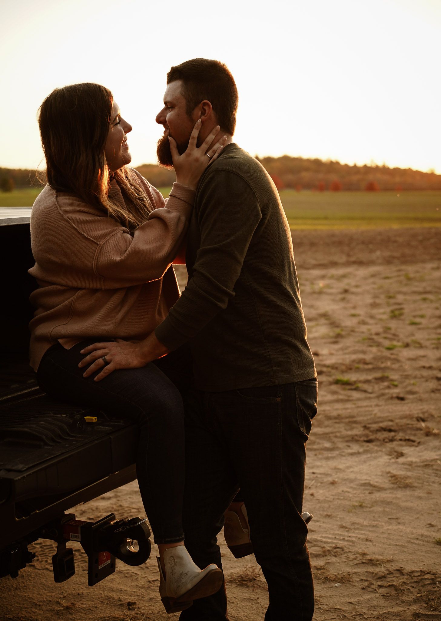Wisconsin Couple and Engagement Photographer - Sunset photo of couple silhouette during engagement session with a trucks in a field.
