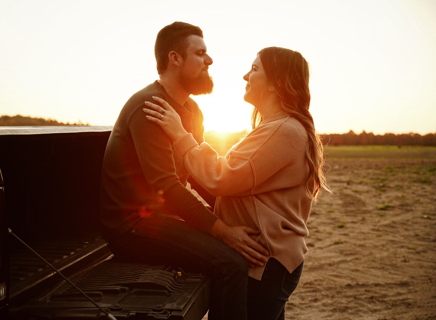 Wisconsin Couple and Engagement Photographer - Sunset photo of couple silhouette during engagement session with a trucks in a field.
