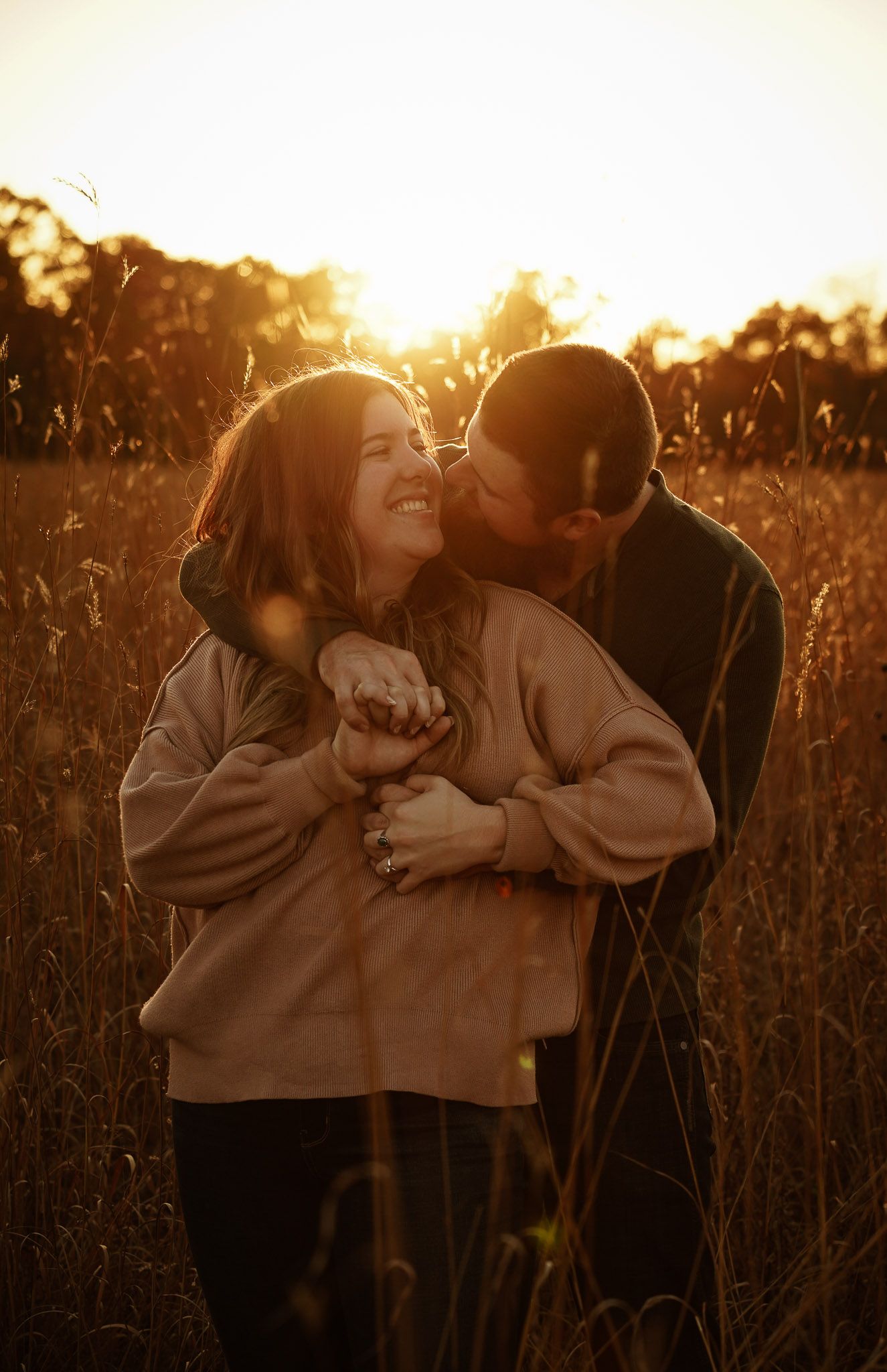 Wisconsin Couple and Engagement Photographer - Couple hugging in a field in fall during an engagement session during sunset.