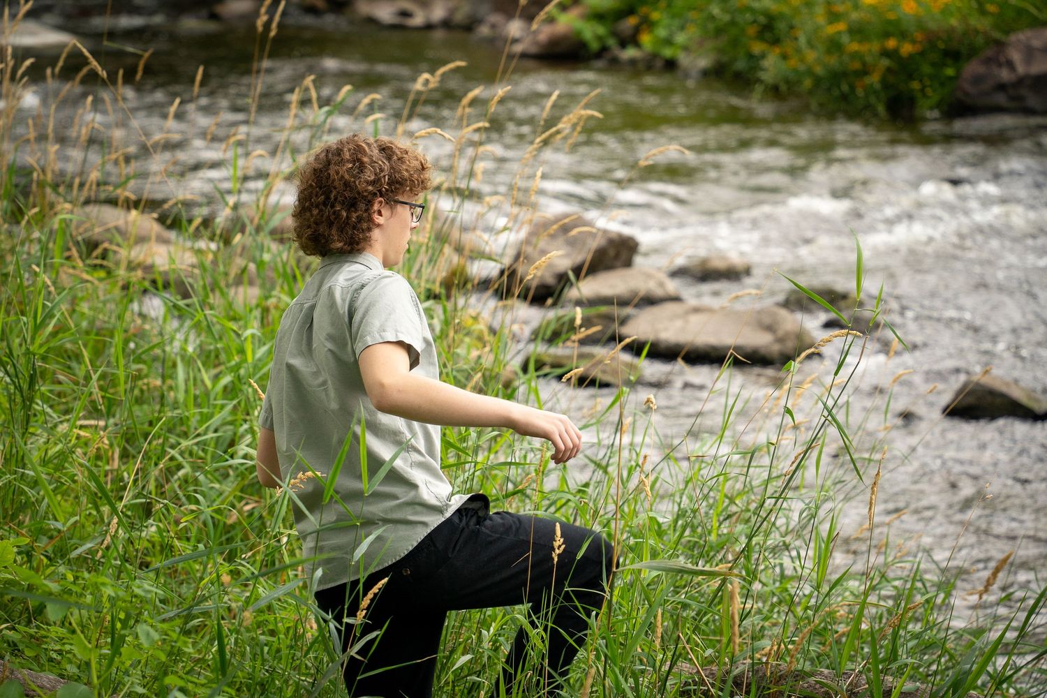 Wisconsin Senior and Portrait Photographer - Boy walking on a rock on river in Wisconsin during a summer senior portrait session.