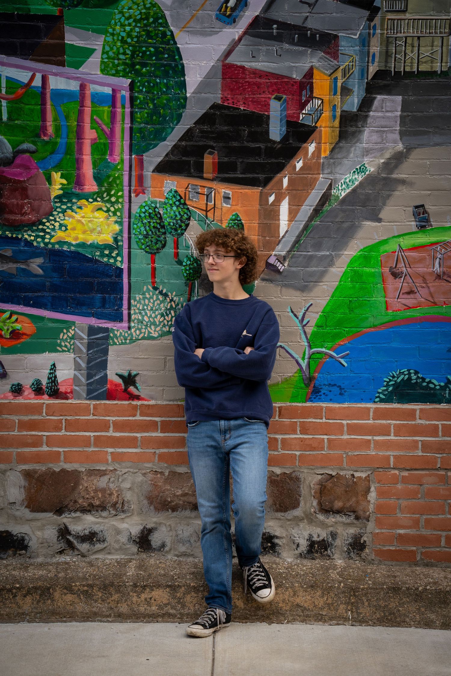 Wisconsin Senior and Portrait Photographer - Boy leaning on wall with city street art in Wisconsin during a summer senior portrait session.