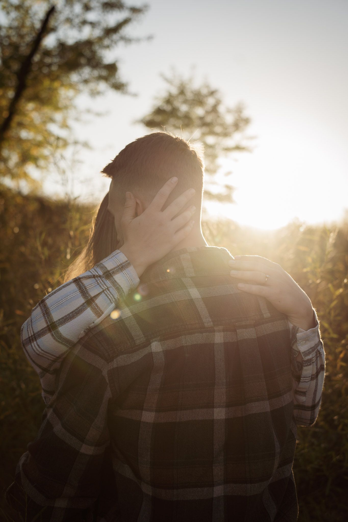 Wisconsin Couple and Engagement Photographer - Couple kissing in a field in fall during an engagement session in WI during sunset.