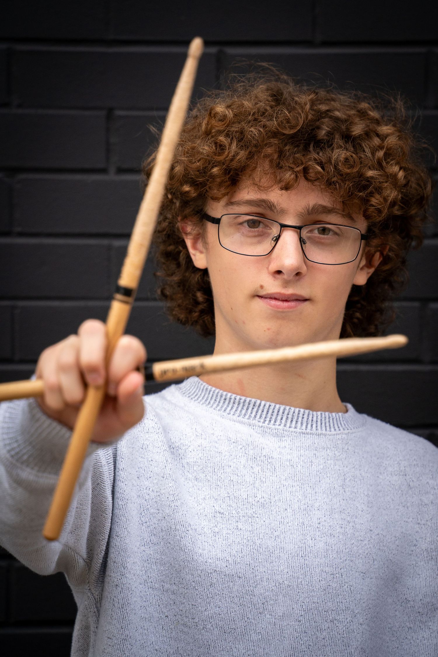 Wisconsin Senior and Portrait Photographer - Drummer senior boy smiling holding drumsticks in Wisconsin during a summer senior portrait.