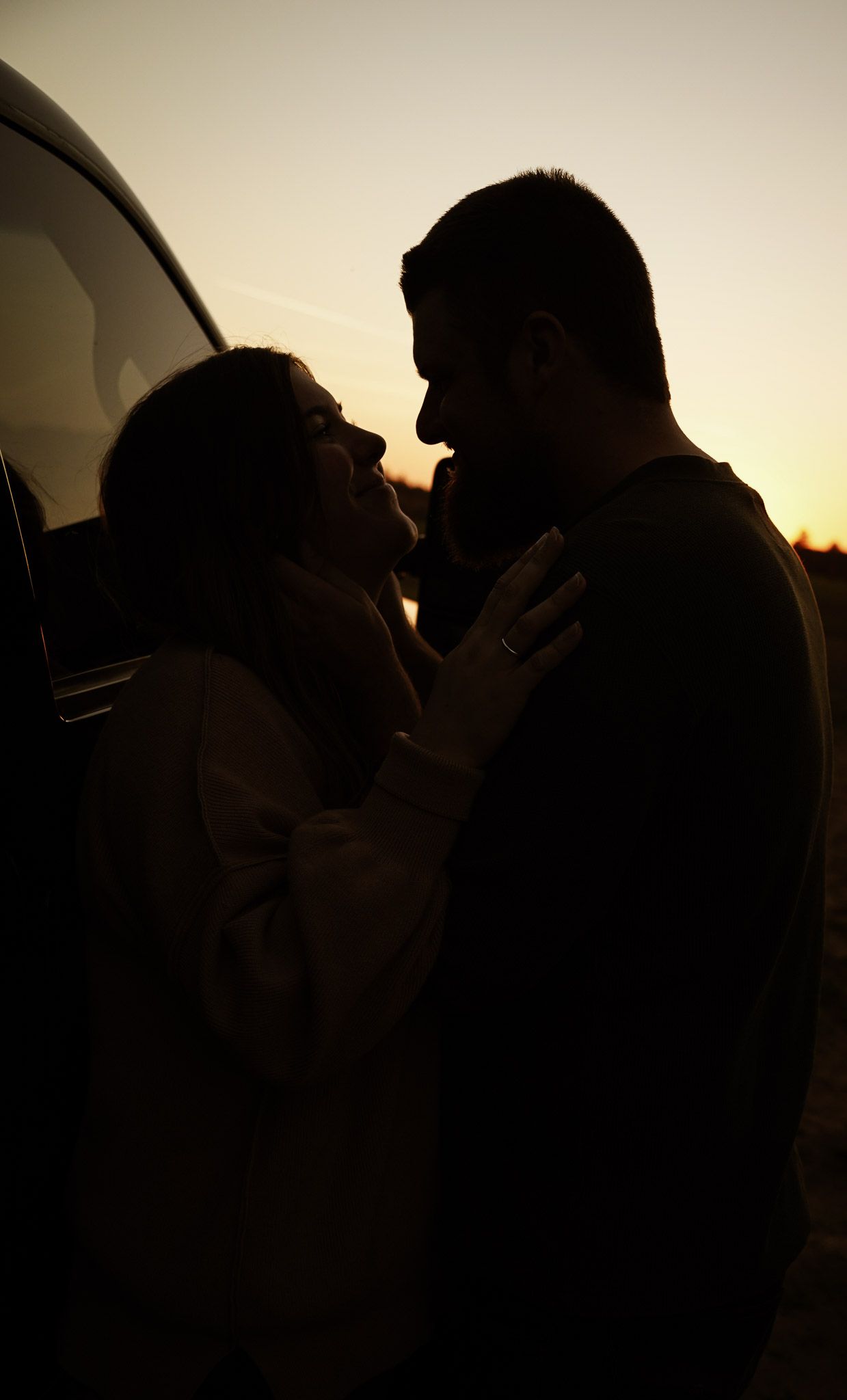 Wisconsin Couple and Engagement Photographer - Sunset photo of couple silhouette during engagement session with a trucks in a field.