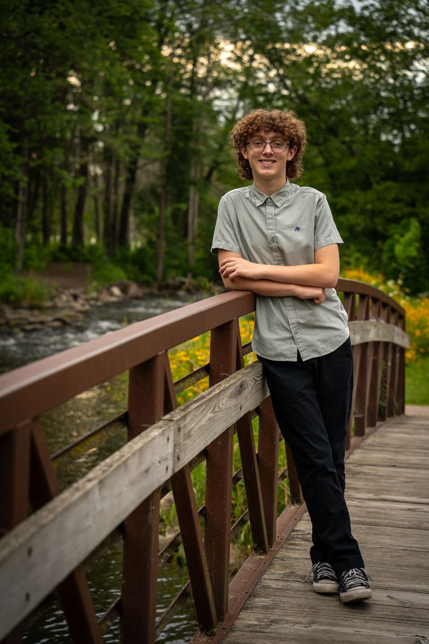 Wisconsin Senior and Portrait Photographer - Boy smiling on a bridge in Wisconsin during a summer senior portrait session.