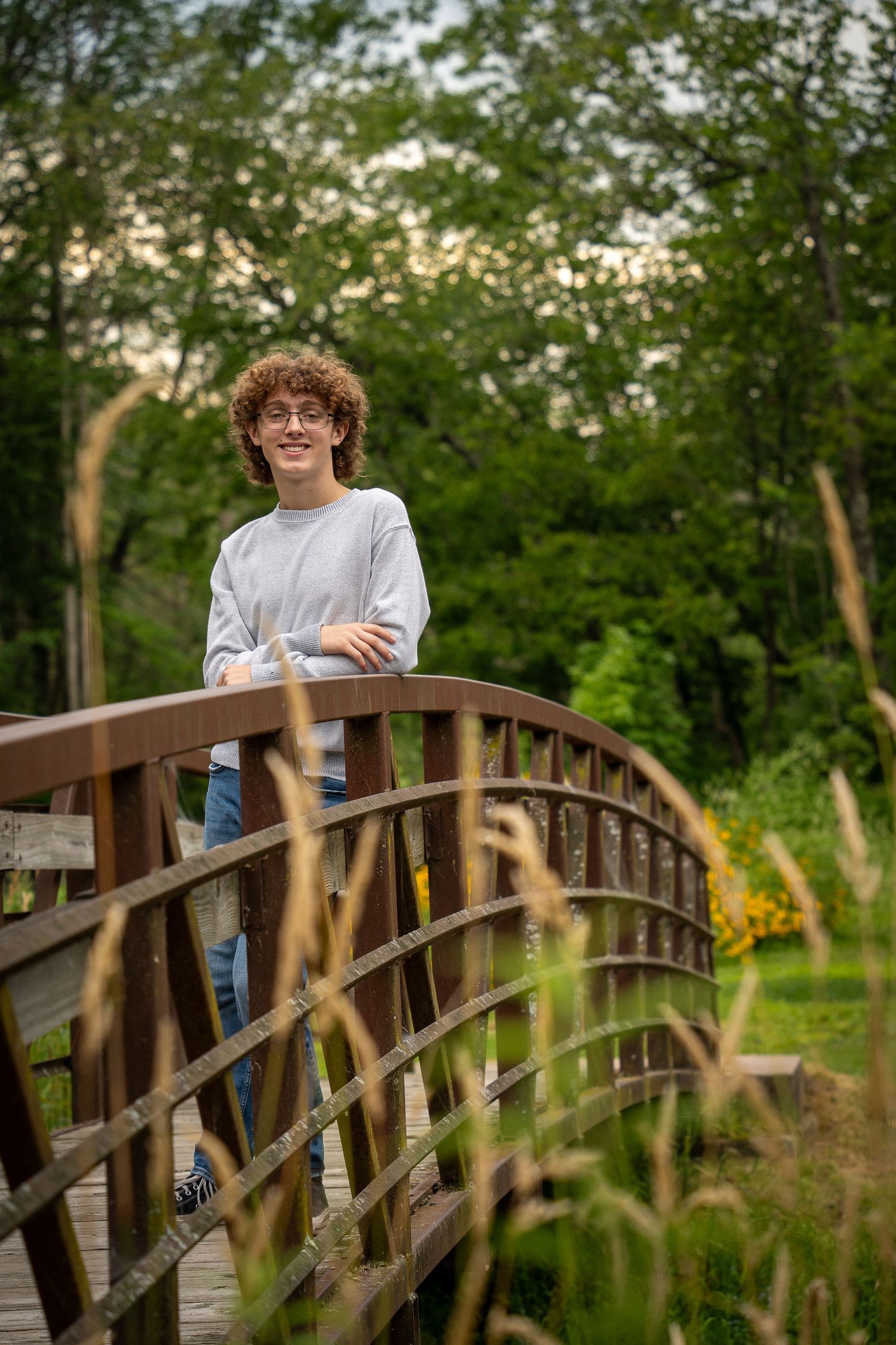 Wisconsin Senior and Portrait Photographer - Boy smiling on a bridge in Wisconsin during a summer senior portrait session.