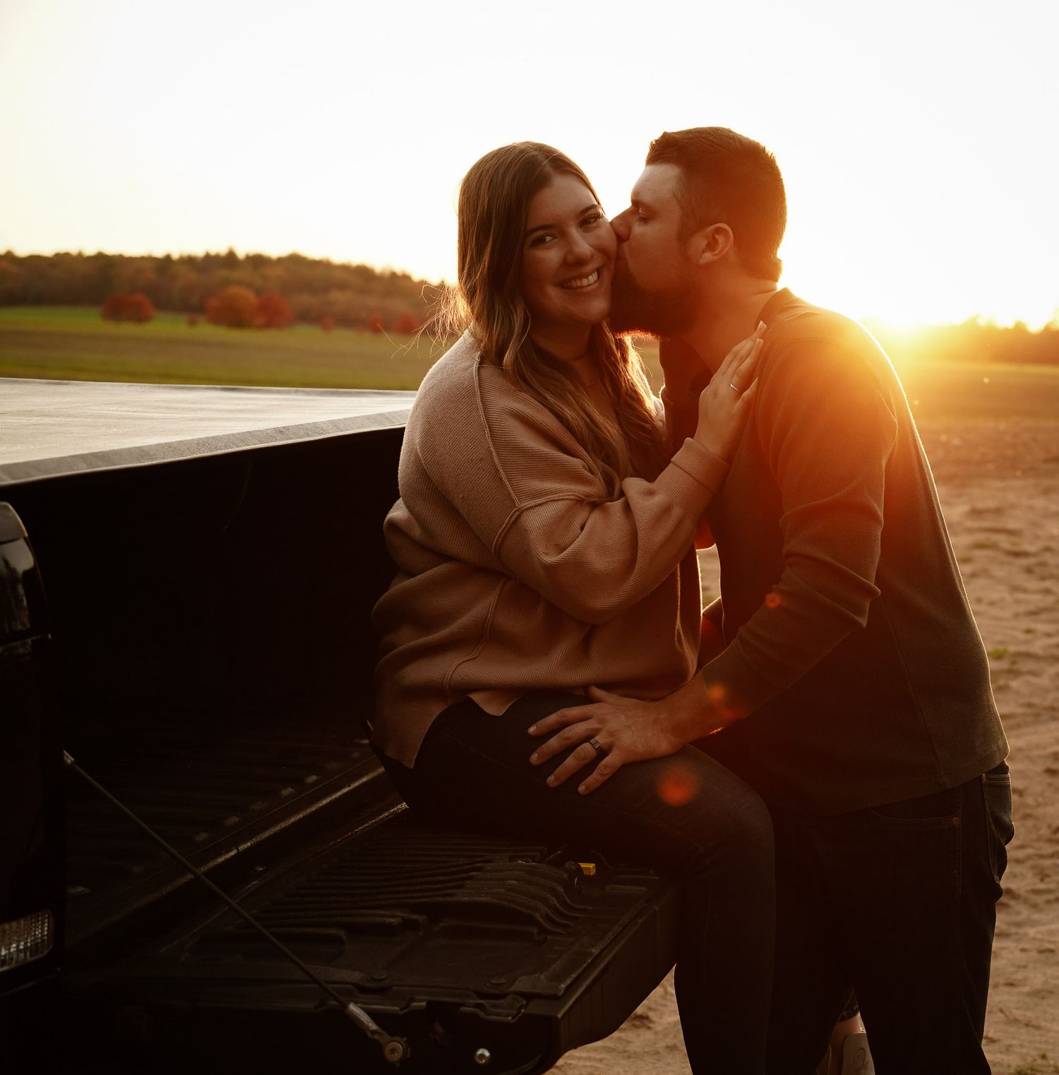 Wisconsin Couple and Engagement Photographer - Sunset photo of couple silhouette during engagement session with a trucks in a field.