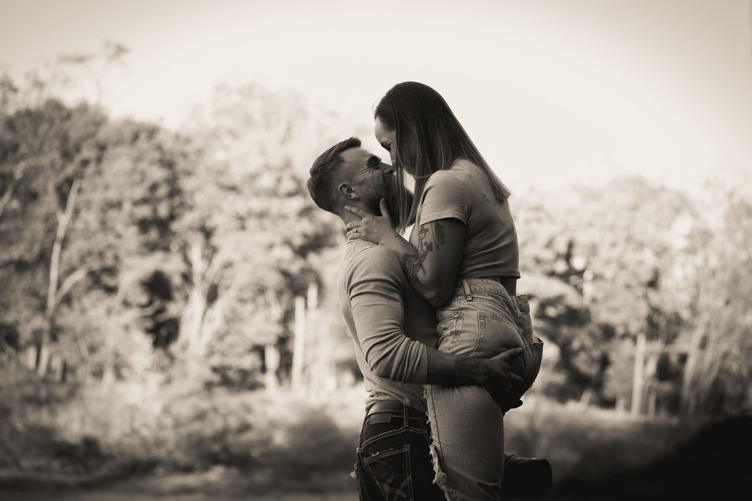 Wisconsin Couple and Engagement Photographer - Couple smiling on riverbank in fall during an engagement session in Wisconsin during sunset.