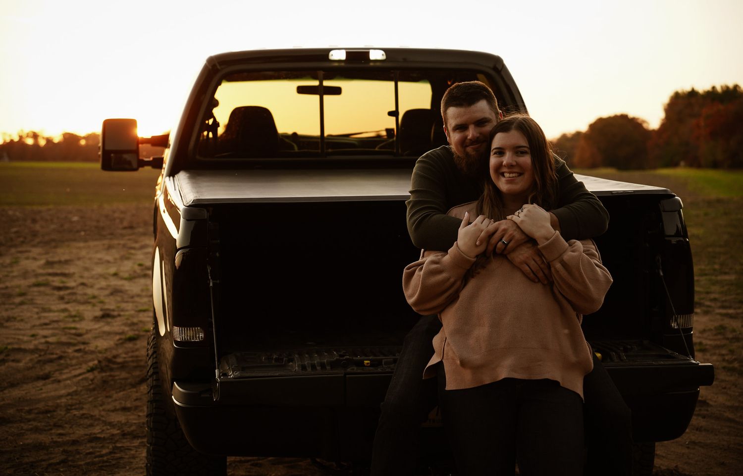 Wisconsin Couple and Engagement Photographer - Sunset photo of couple silhouette during engagement session with a trucks in a field.