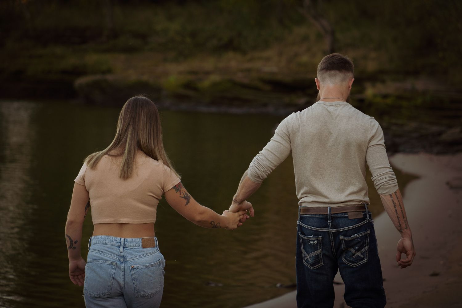 Wisconsin Couple and Engagement Photographer - Couple walking on a beach in fall during an engagement session in Wisconsin during sunset.